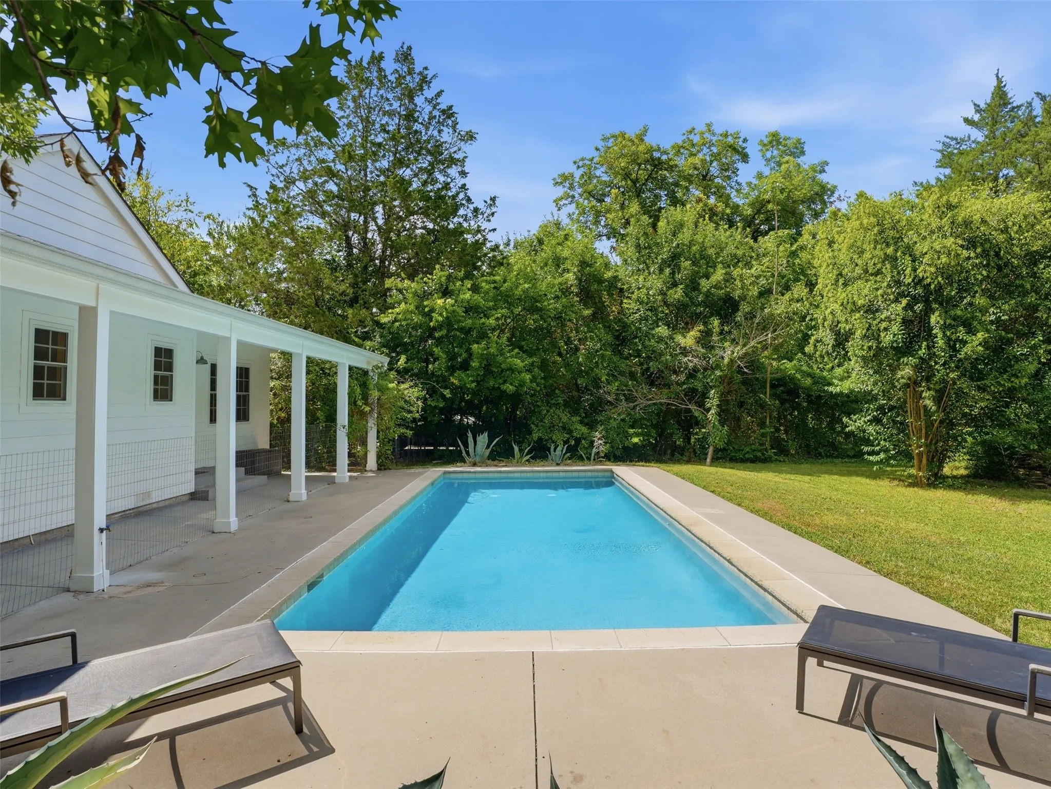 Rectangular swimming pool with a surrounding concrete patio