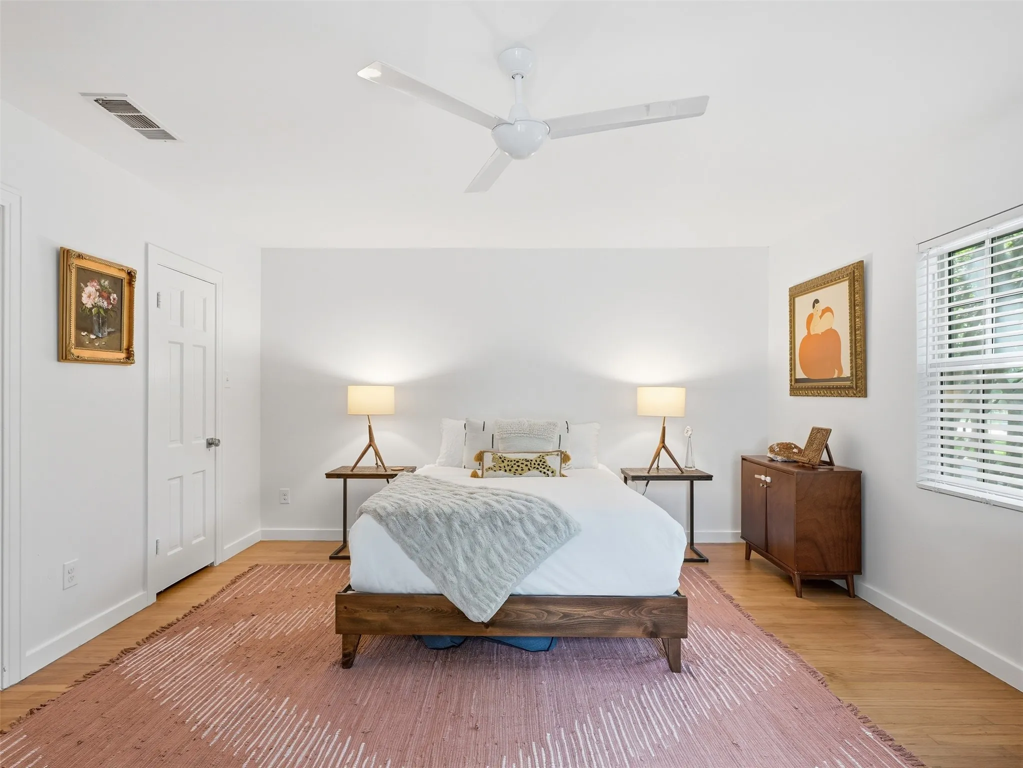 Bright room featuring a modern ceiling fan, wood-finish flooring, and white walls