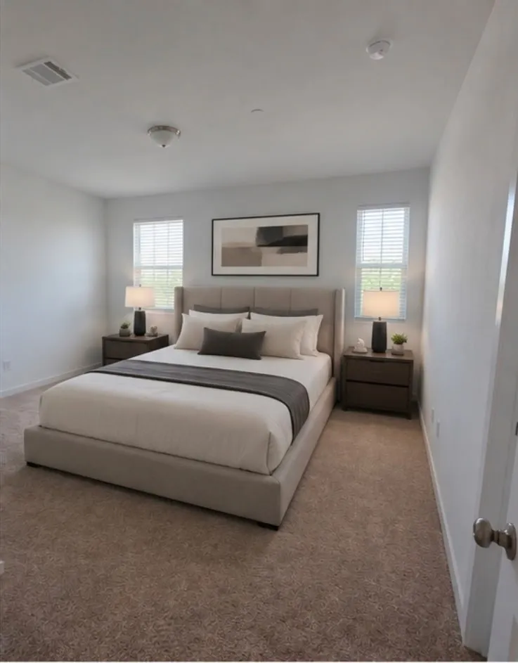 Carpeted room featuring two windows with horizontal blinds, a ceiling-mounted light fixture, and a ceiling air vent