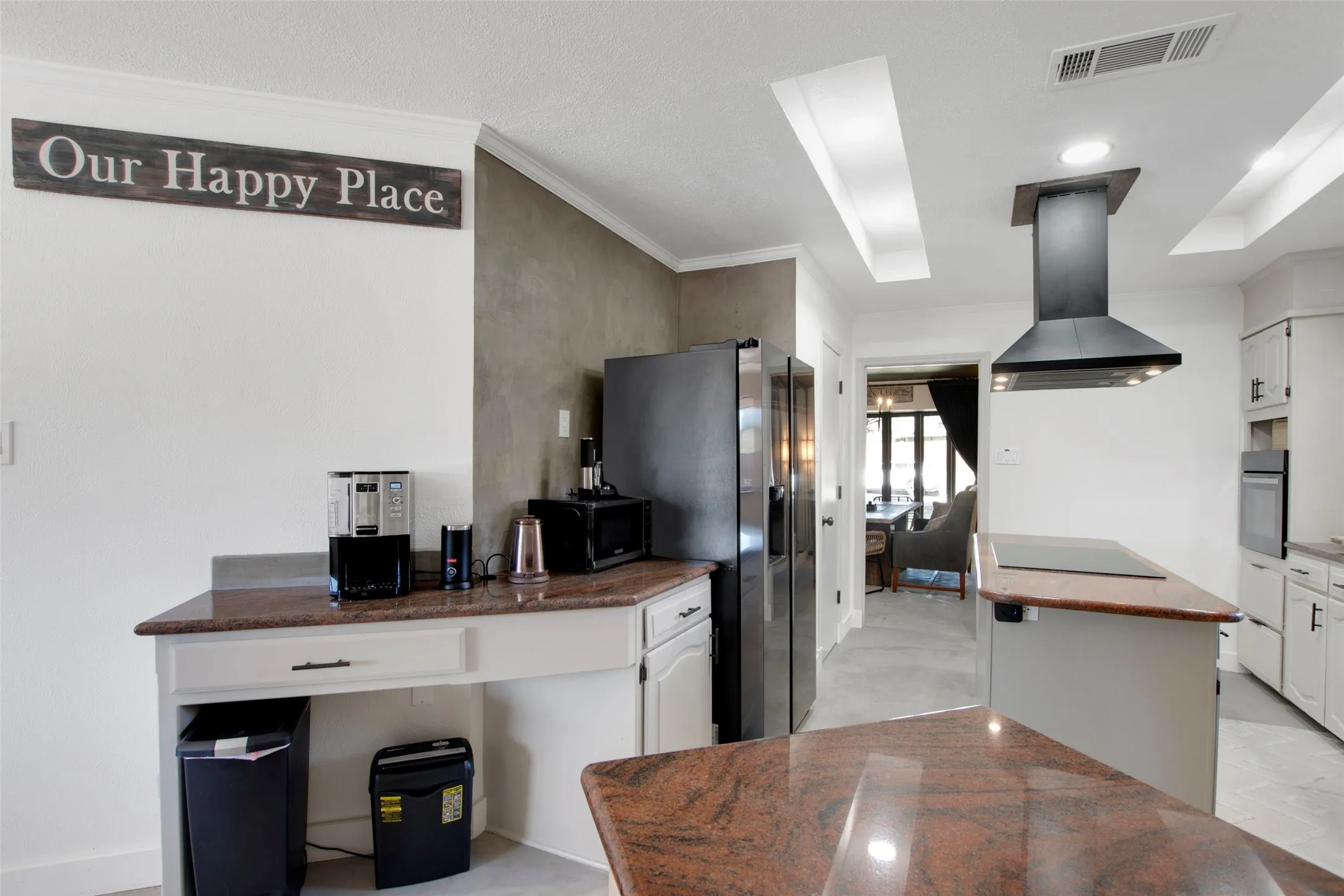 Kitchen featuring white cabinets, island exhaust hood, appliances with stainless steel finishes, and ornamental molding