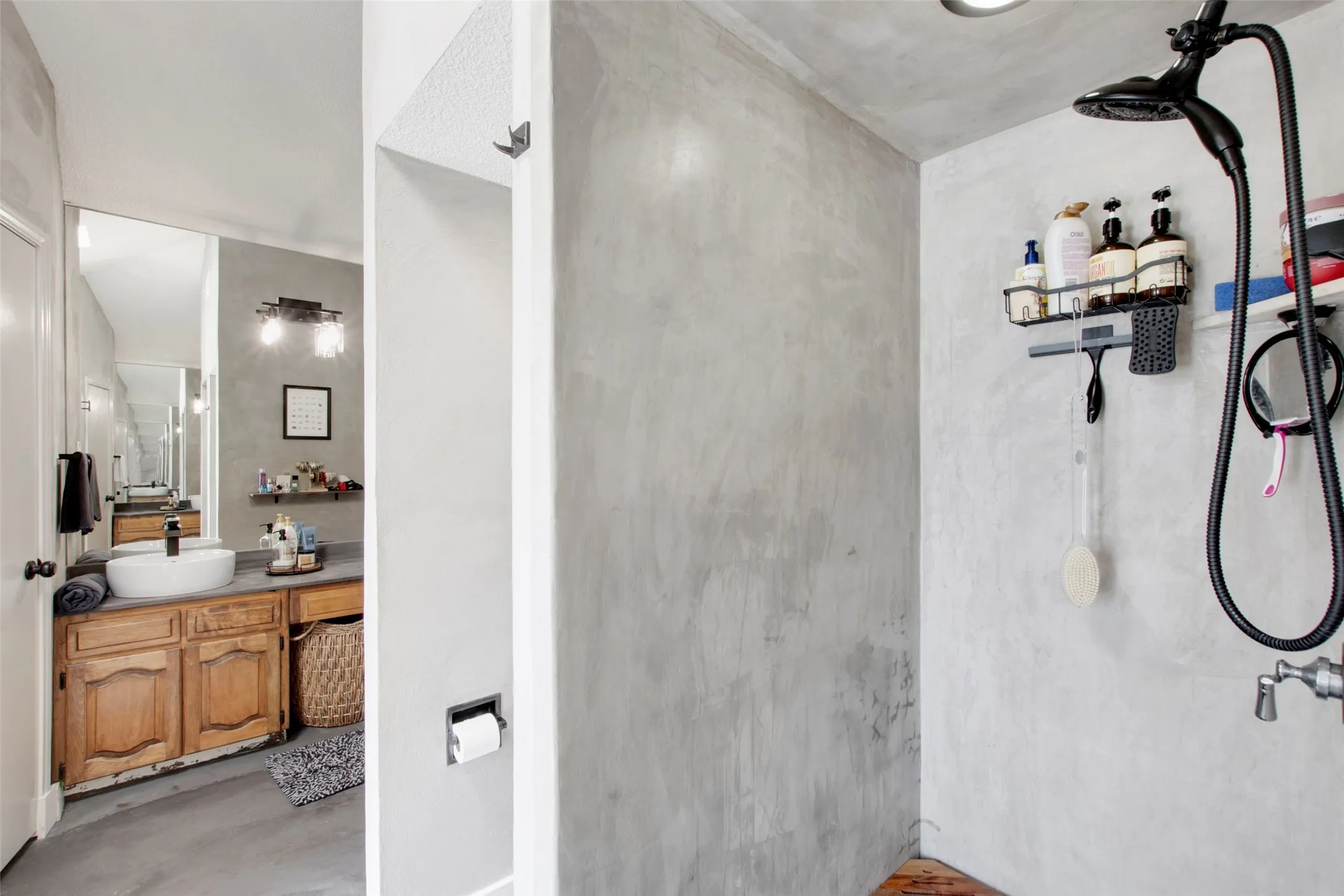 Bathroom with walk in shower, concrete flooring, and vanity
