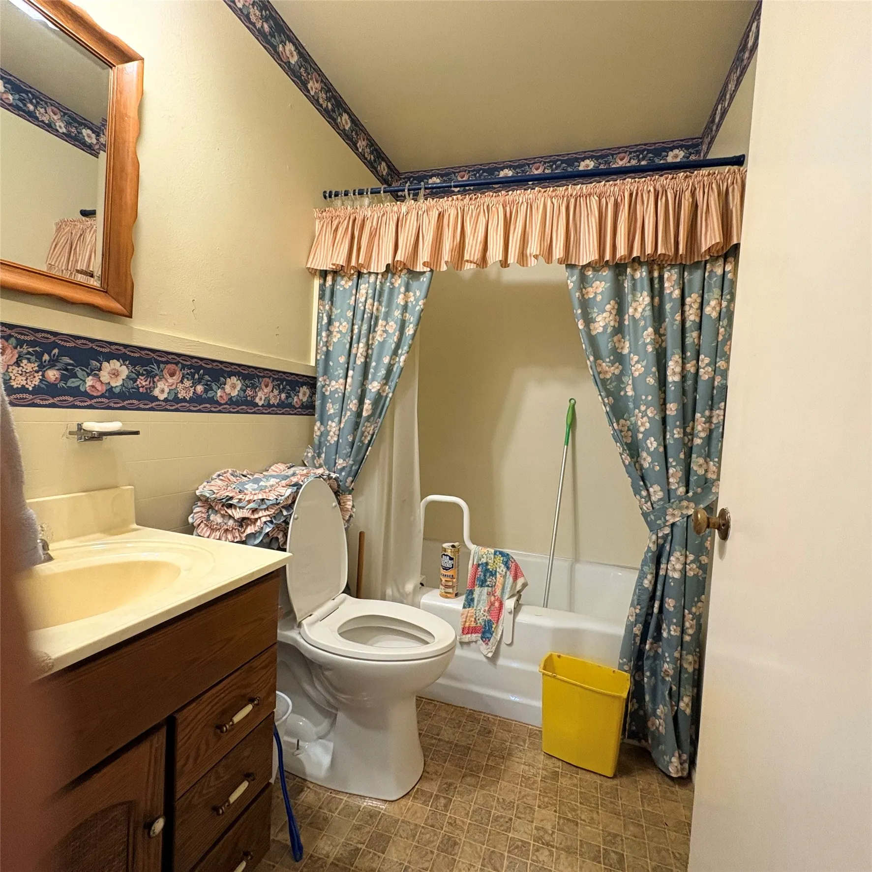 Bathroom featuring a wood-finish vanity with a beige countertop, a mounted mirror, and a white toilet