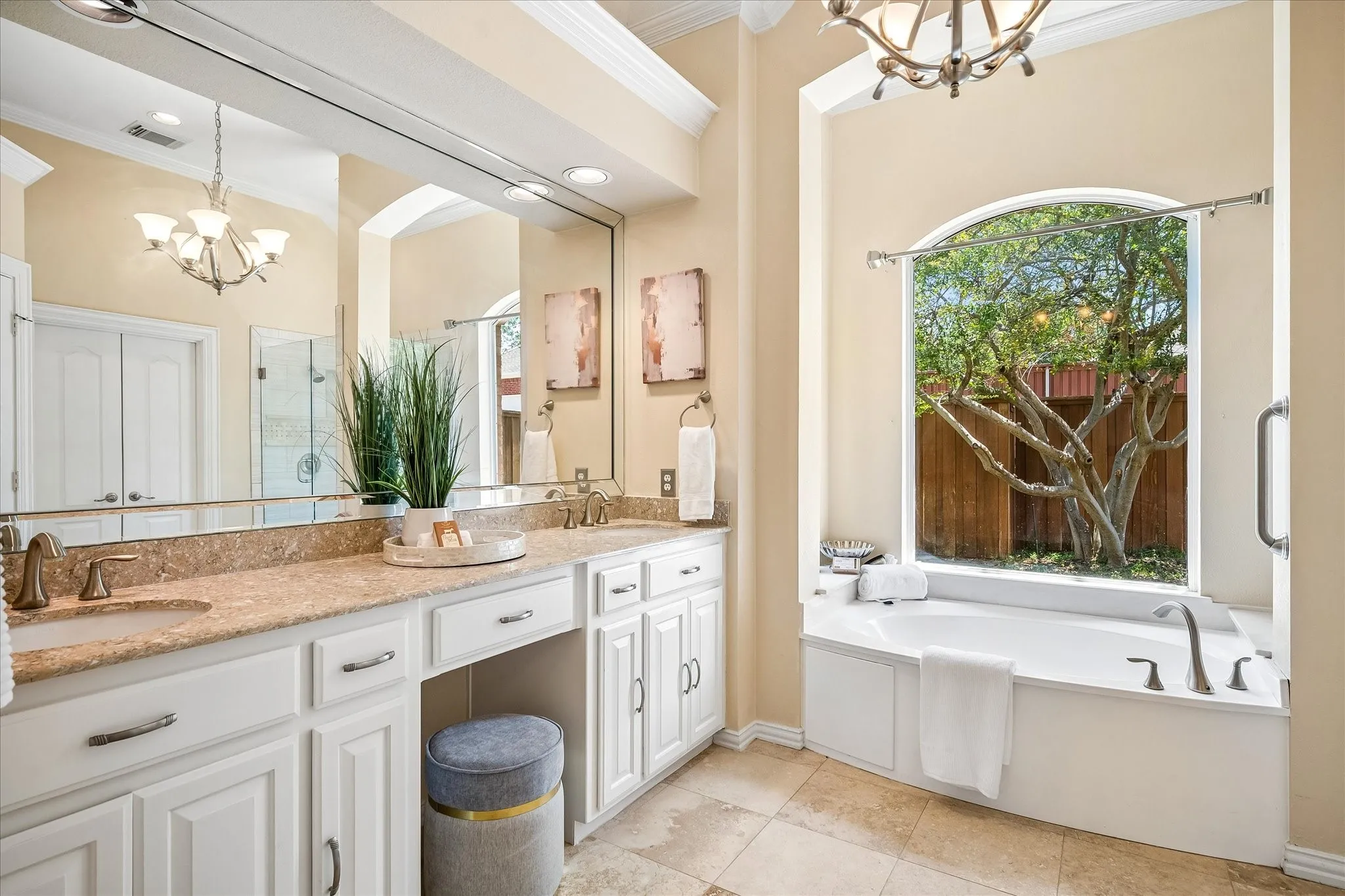 Primary bathroom with garden tub and picture window overlooking backyard.