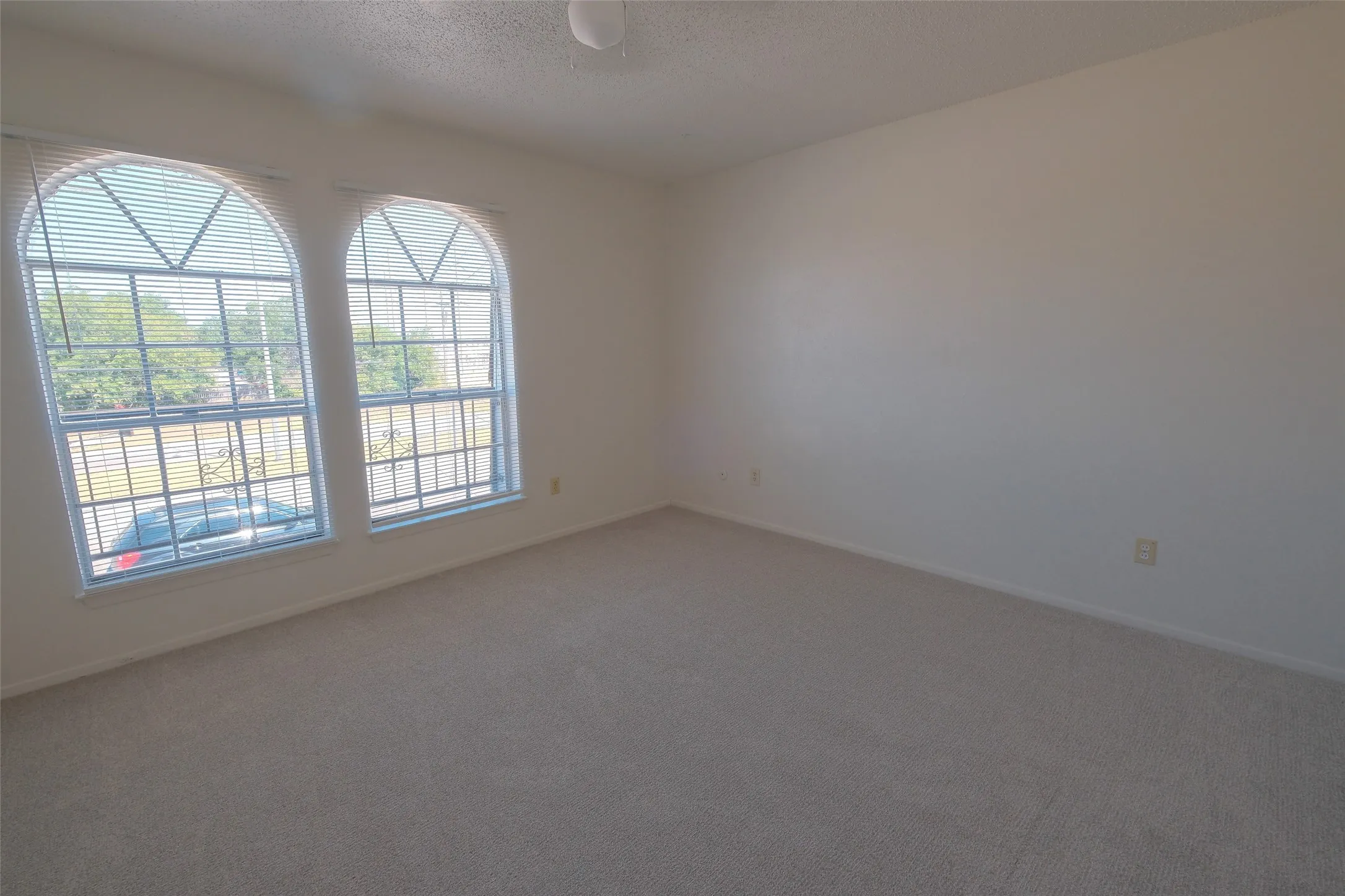 Spacious room featuring neutral carpeting and light-colored walls