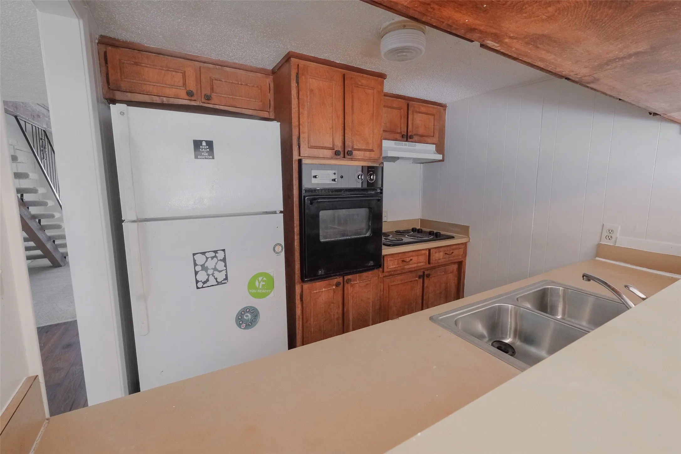 Kitchen featuring a double basin stainless steel sink, built-in oven, gas cooktop, and wood cabinetry