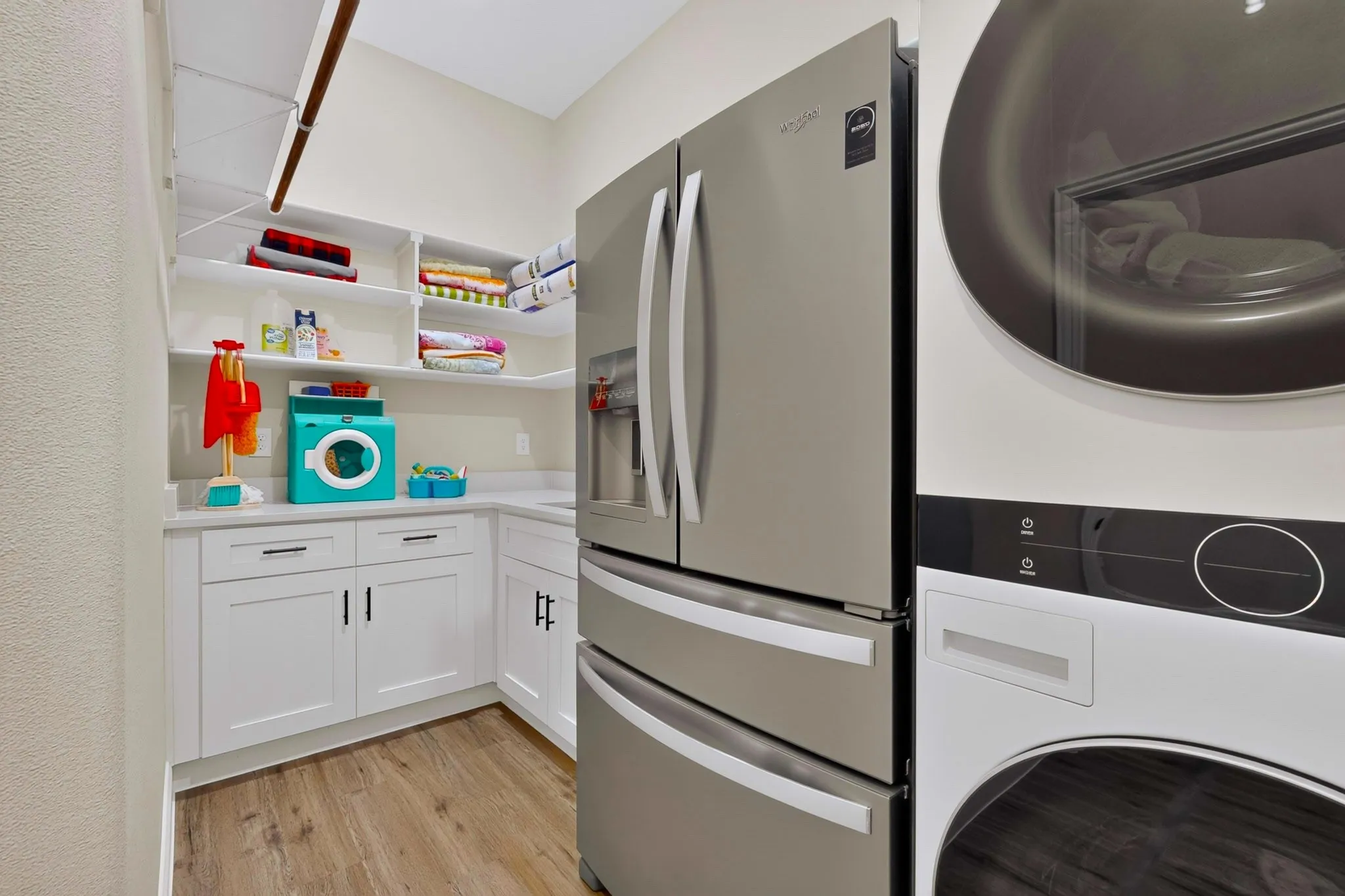 SS sink, fridge or freezer space if you stack the washer-dryer.  Located next to the primary retreat and behind the kitchen hallway.