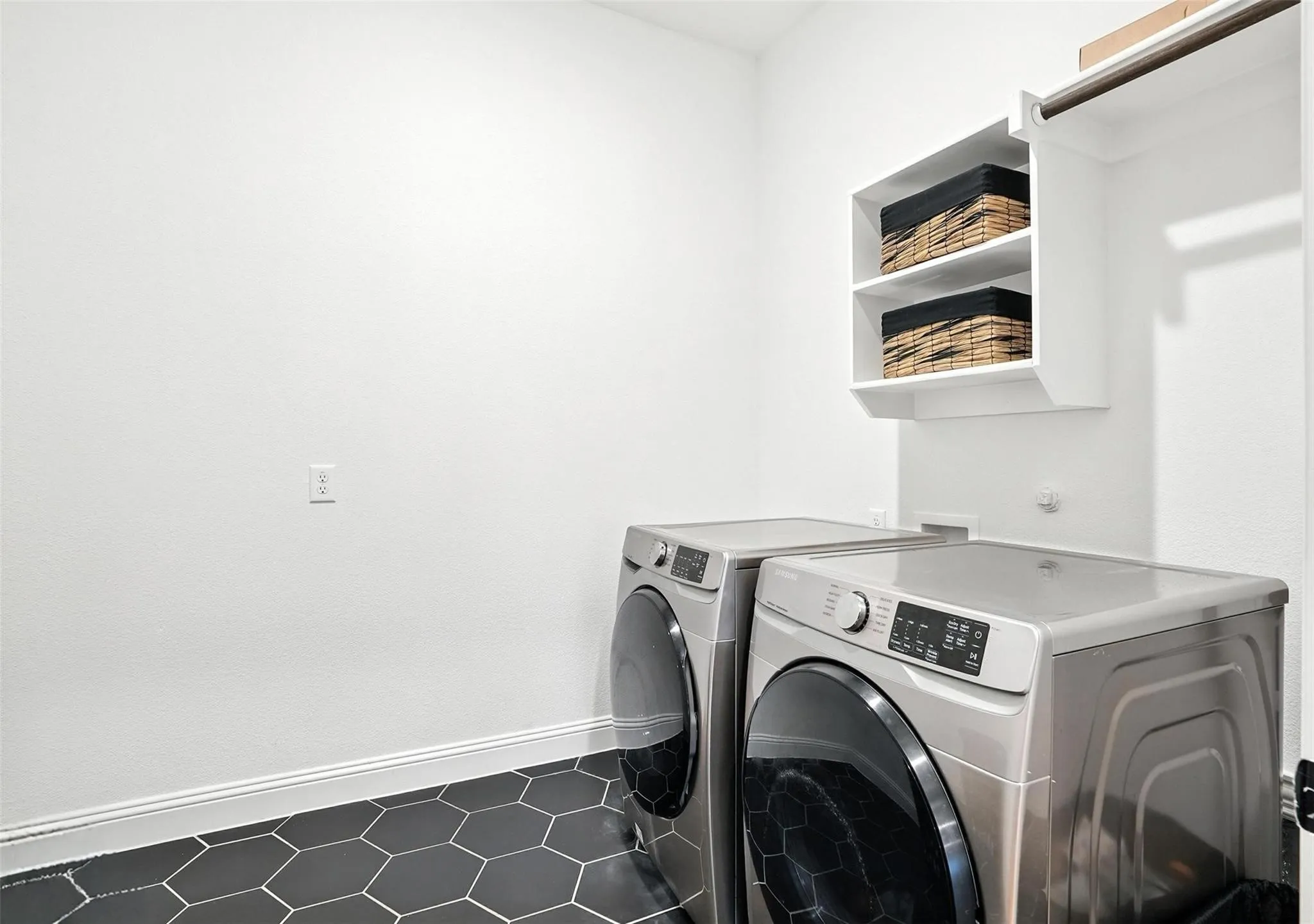 Laundry room with washer and clothes dryer and baseboards