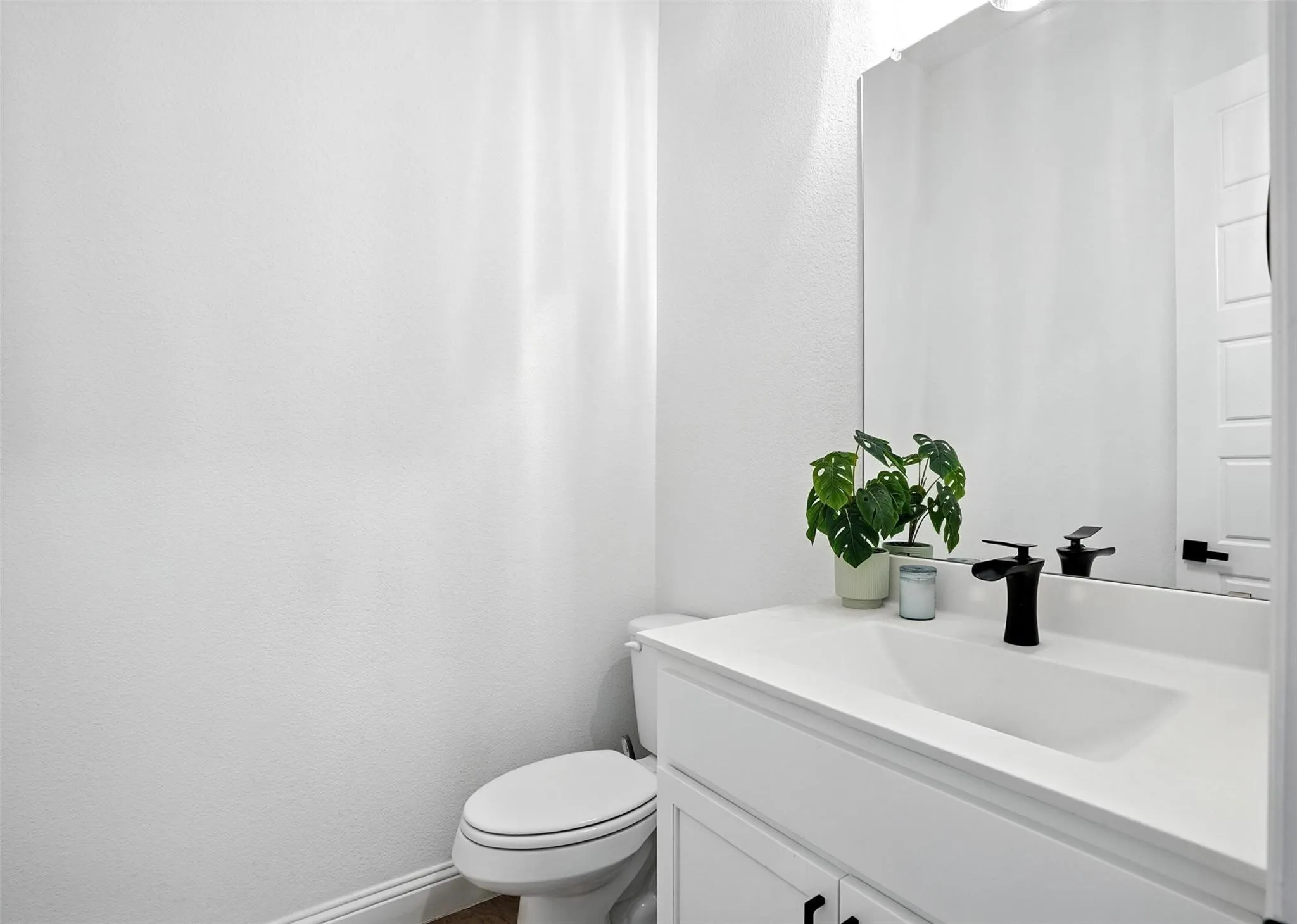 Half bath with vanity and a textured wall