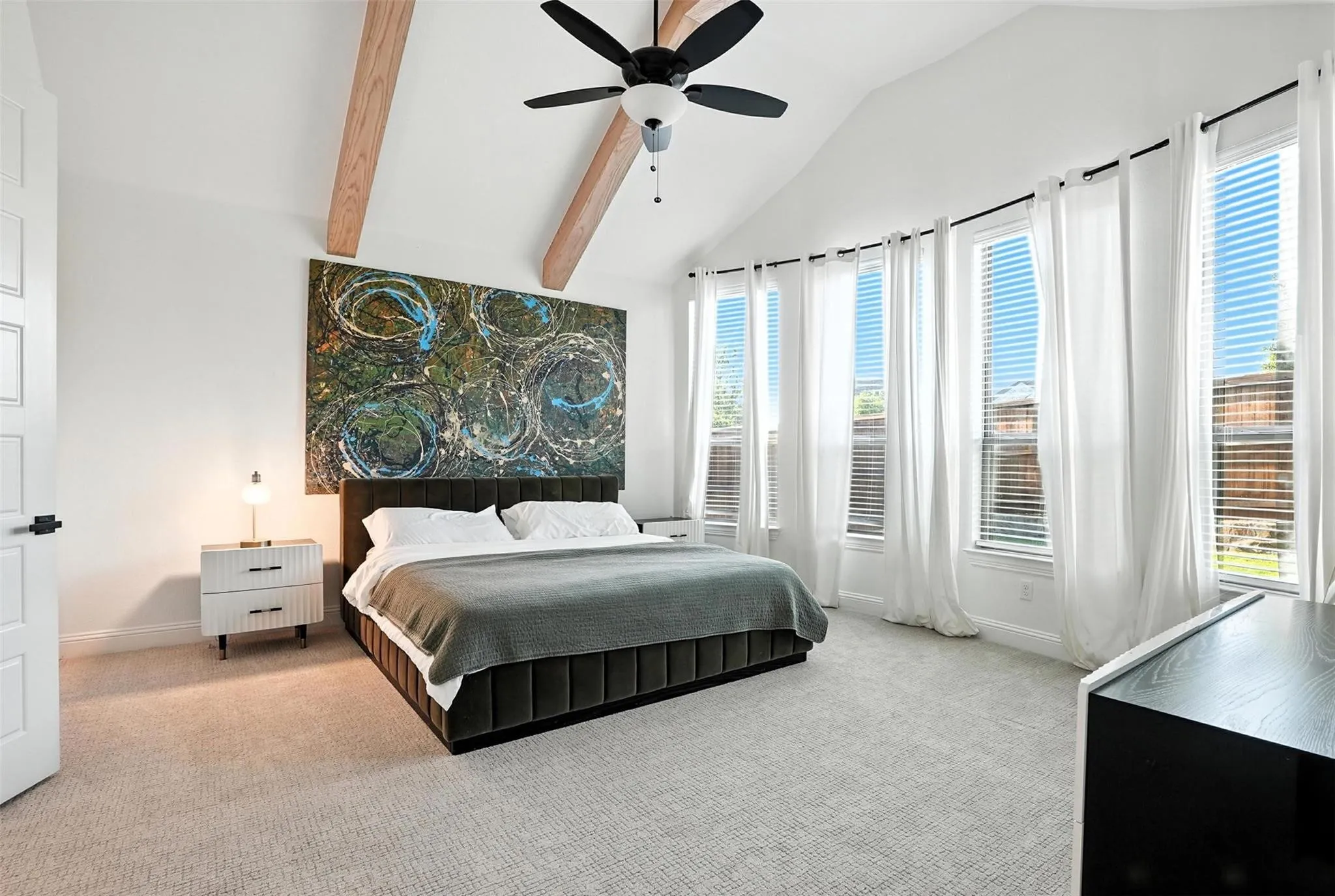 Bedroom with carpet flooring, high vaulted ceiling, beamed ceiling, multiple windows, and a ceiling fan