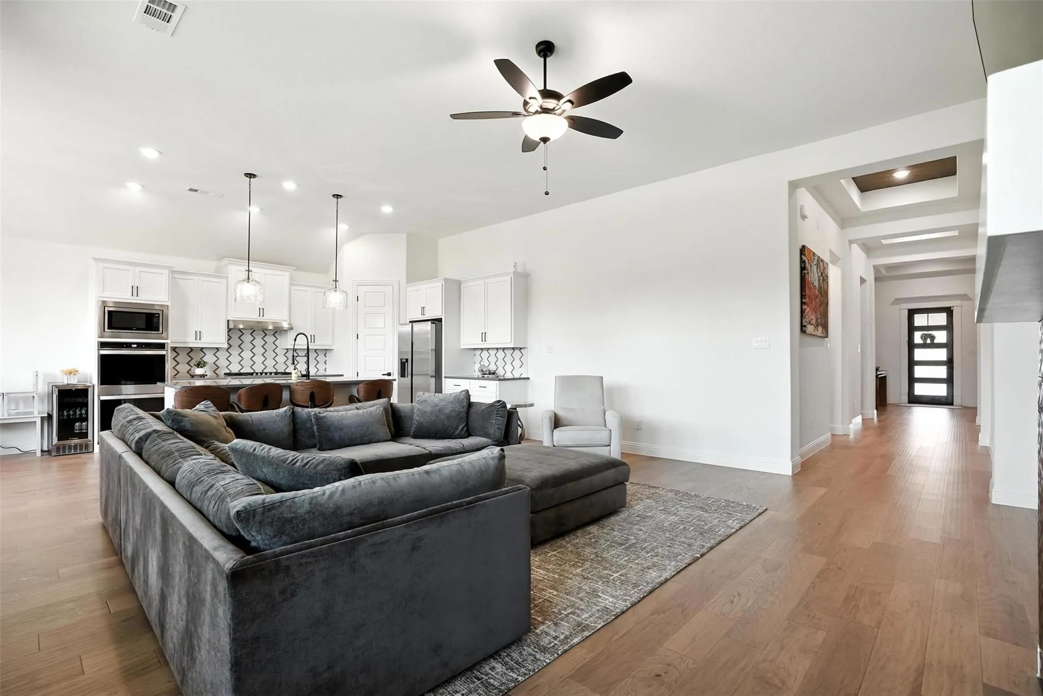Living area featuring recessed lighting, a ceiling fan, light wood-style flooring, and beverage cooler