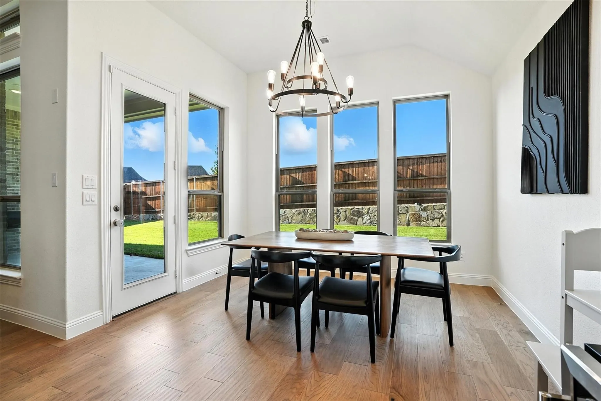 Dining space featuring a chandelier, light wood-style floors, and lofted ceiling