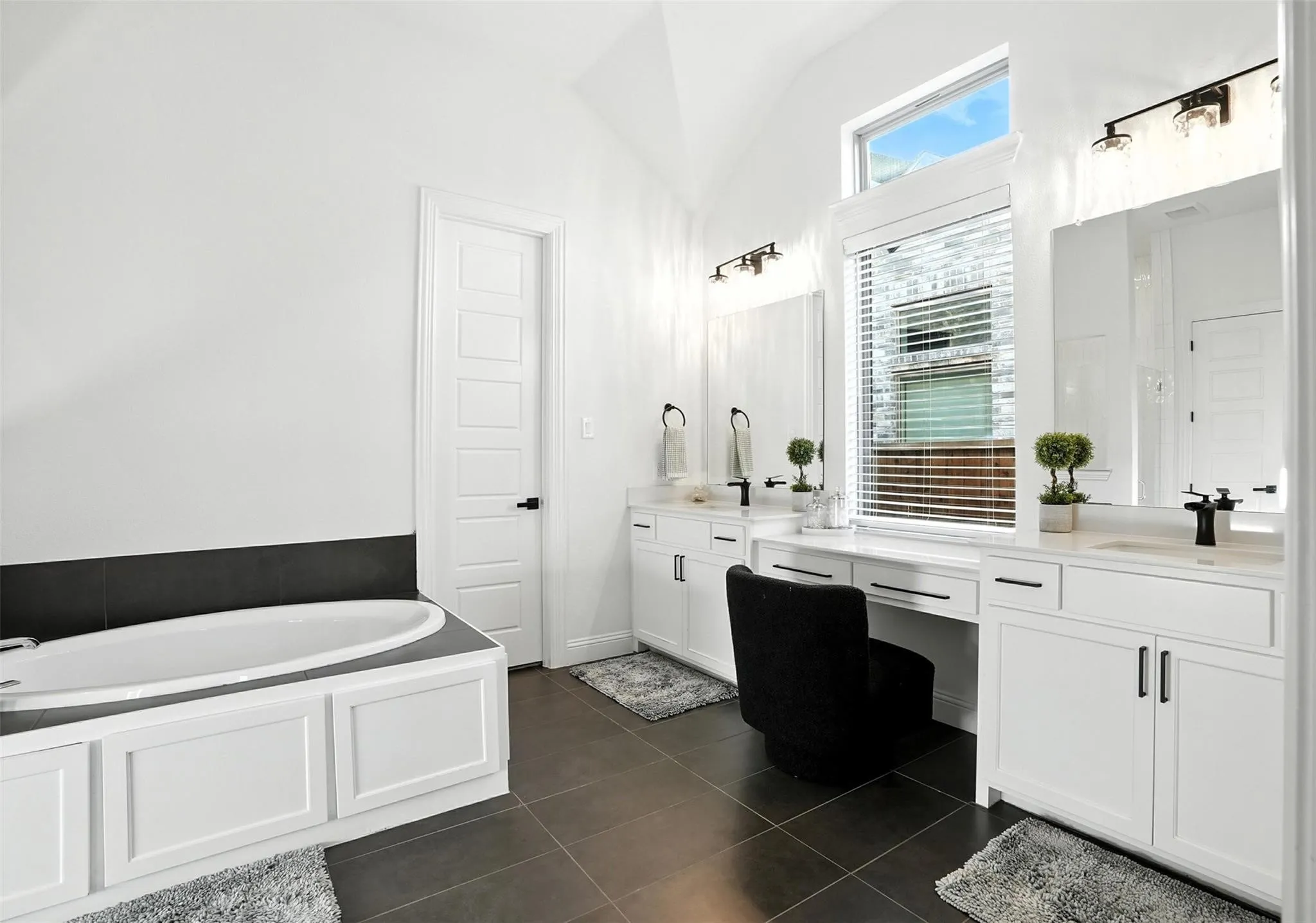 Bathroom with vanity, tile patterned floors, and a bath