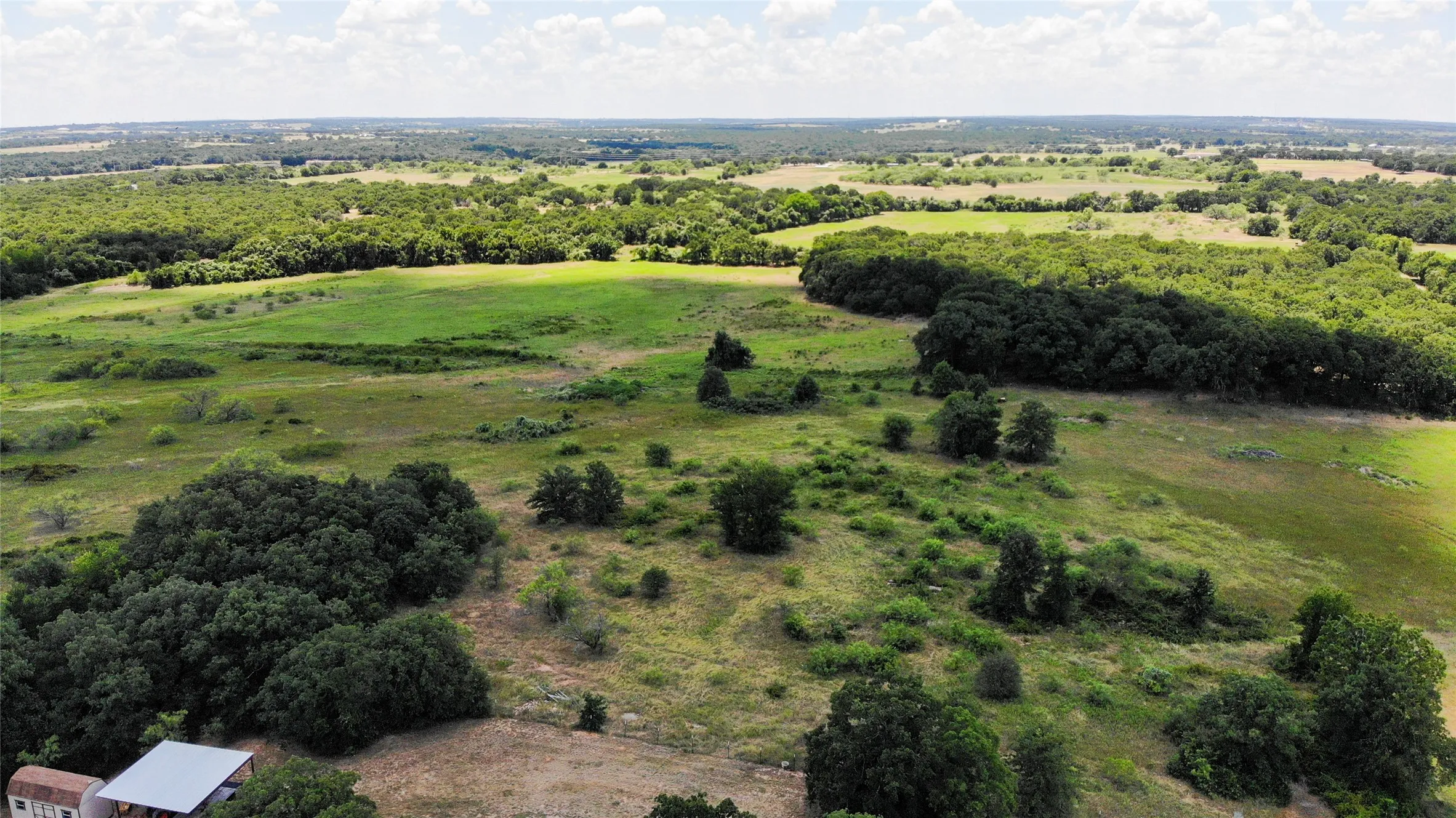 Expansive undeveloped land featuring diverse tree cover and open grassy areas