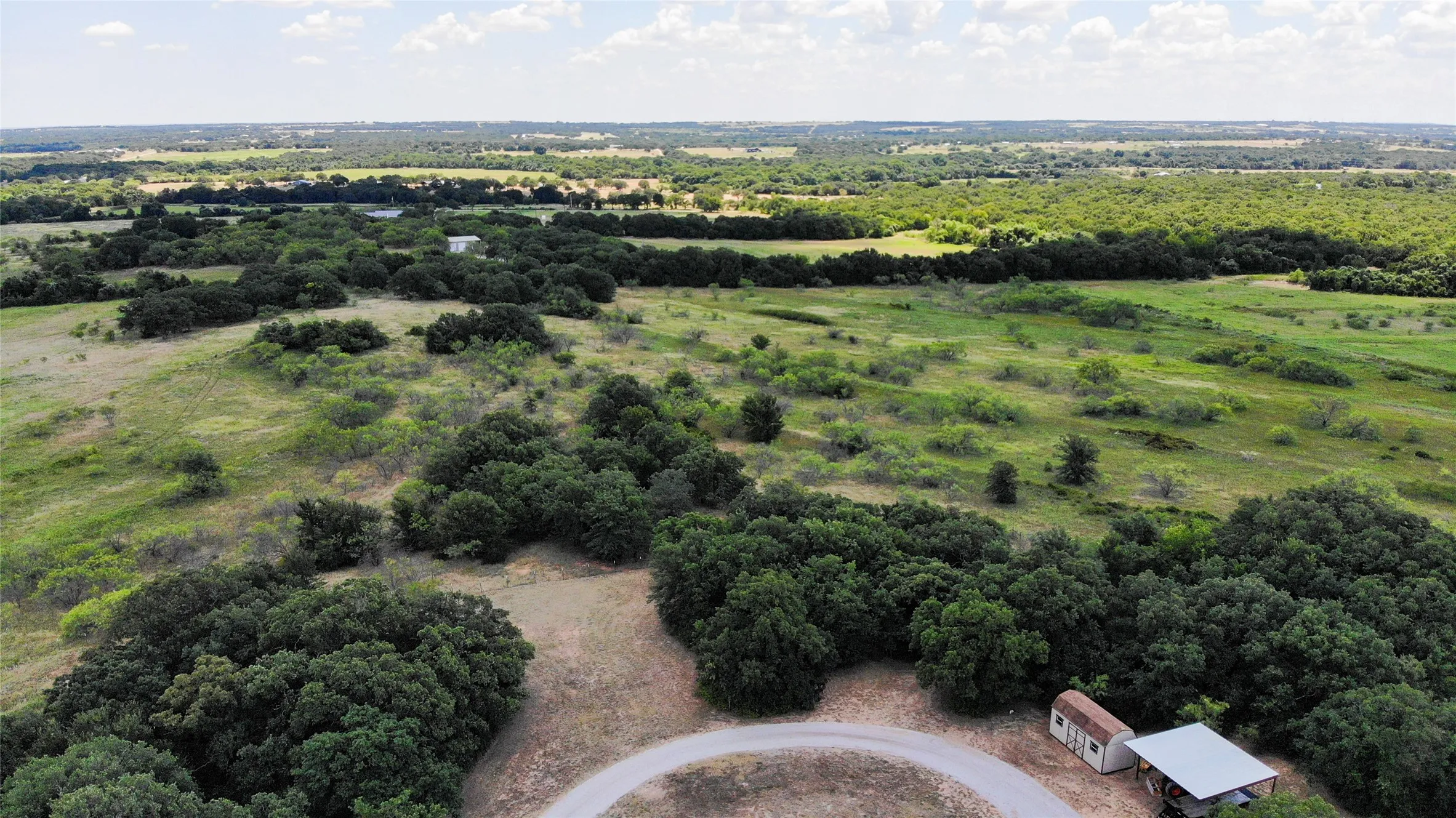 Expansive natural landscape featuring rolling terrain and abundant mature trees