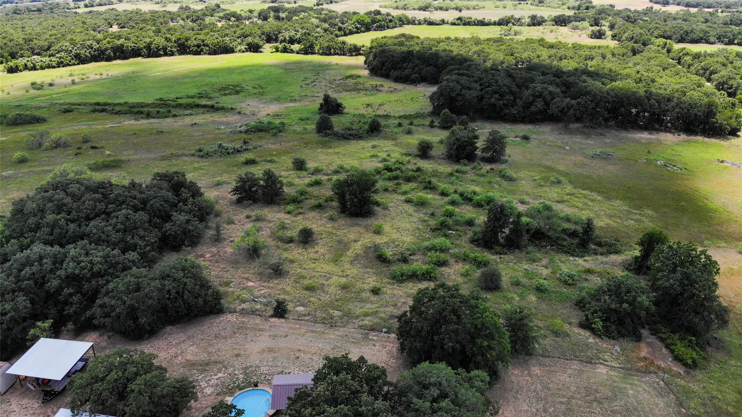 Expansive acreage featuring a mix of open fields and mature tree lines