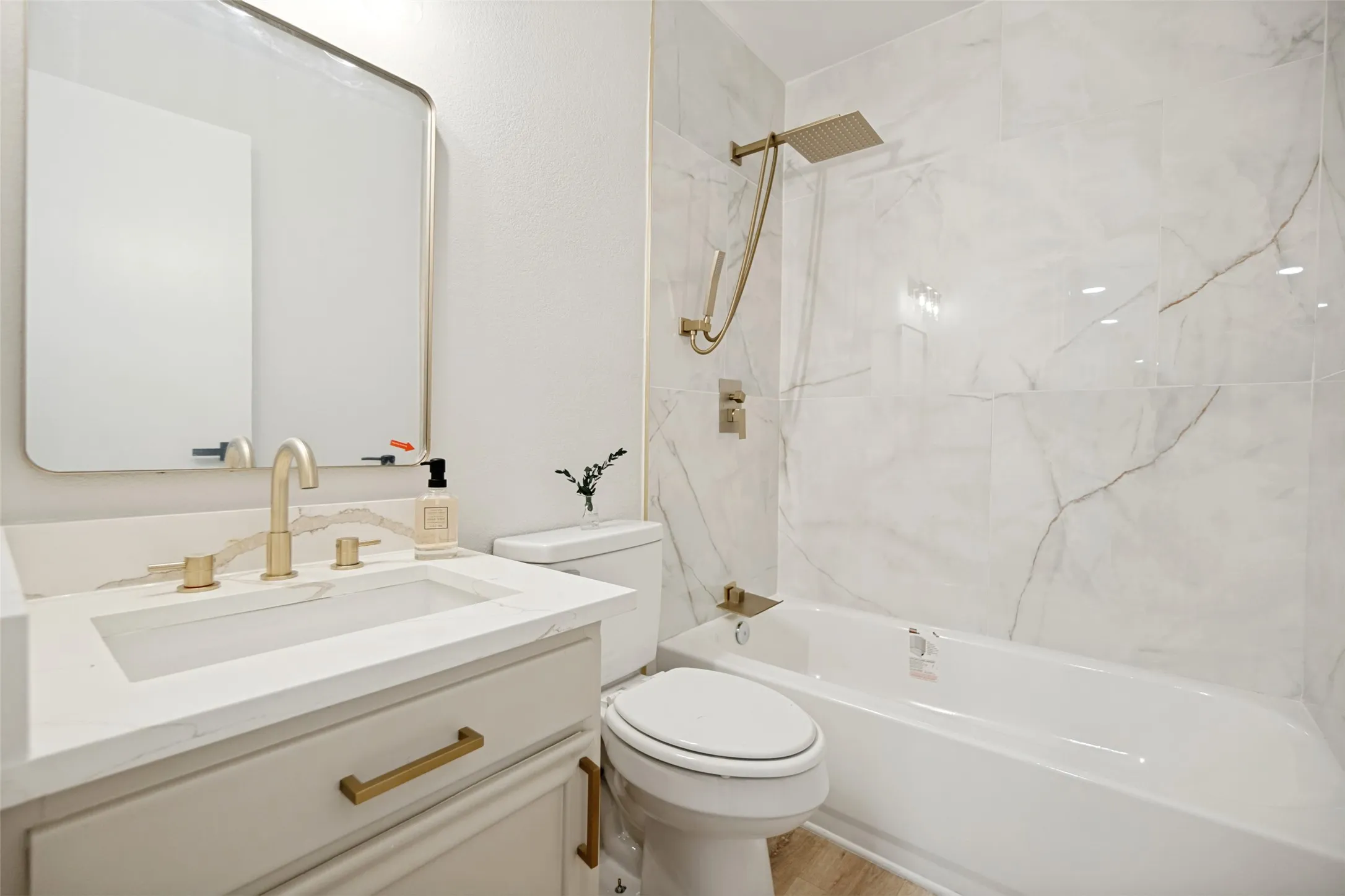 Bathroom featuring a white vanity with a rectangular basin sink and gold-tone fixtures