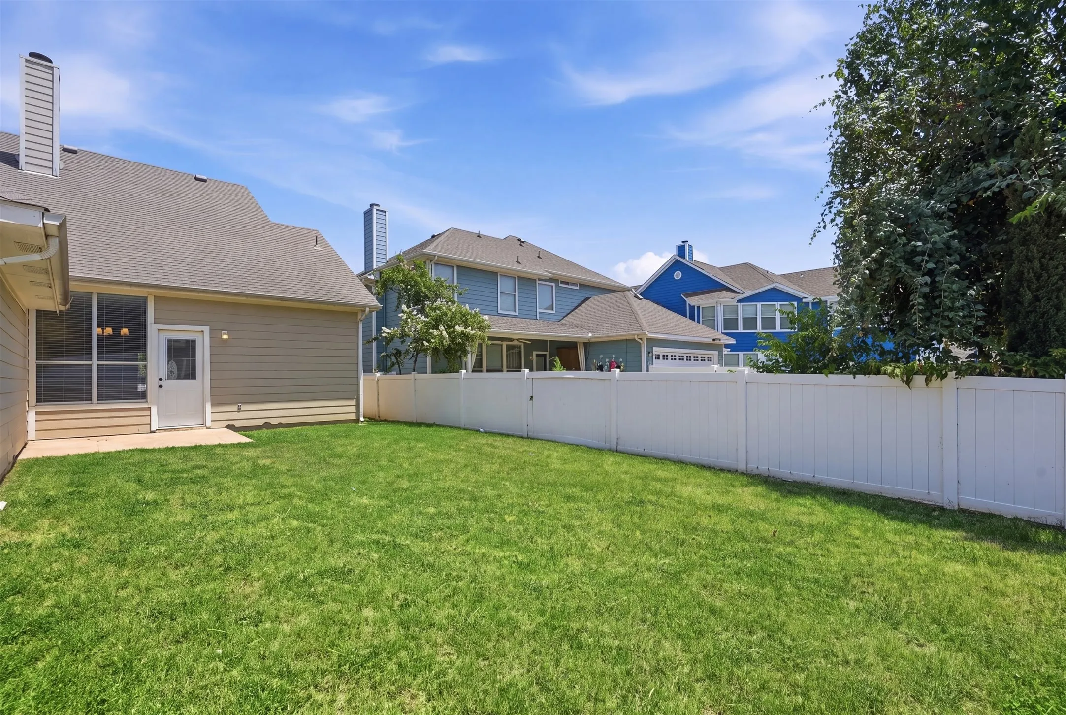 Enjoy a peaceful backyard surrounded by privacy fencing and mature trees, creating a comfortable extension of the home's living space.