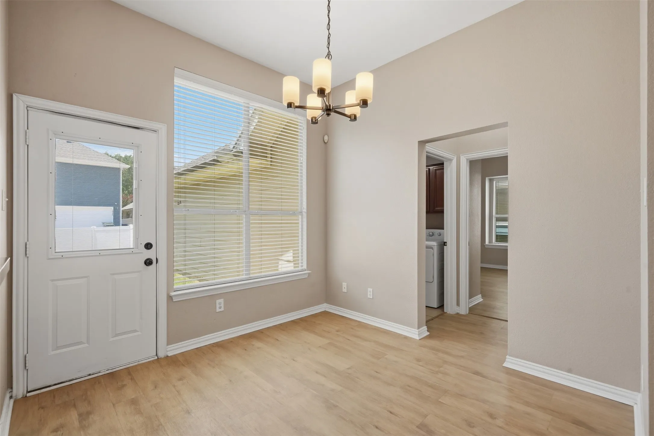 arge windows and a glass exterior door fill the dining space with abundant natural light.