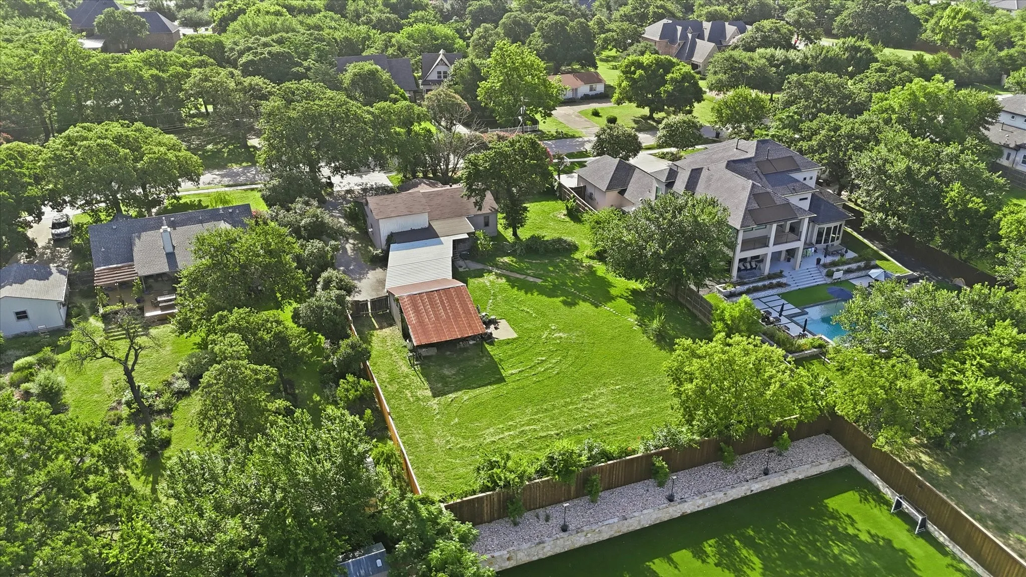 Expansive green lawn with mature trees and a rustic detached outbuilding