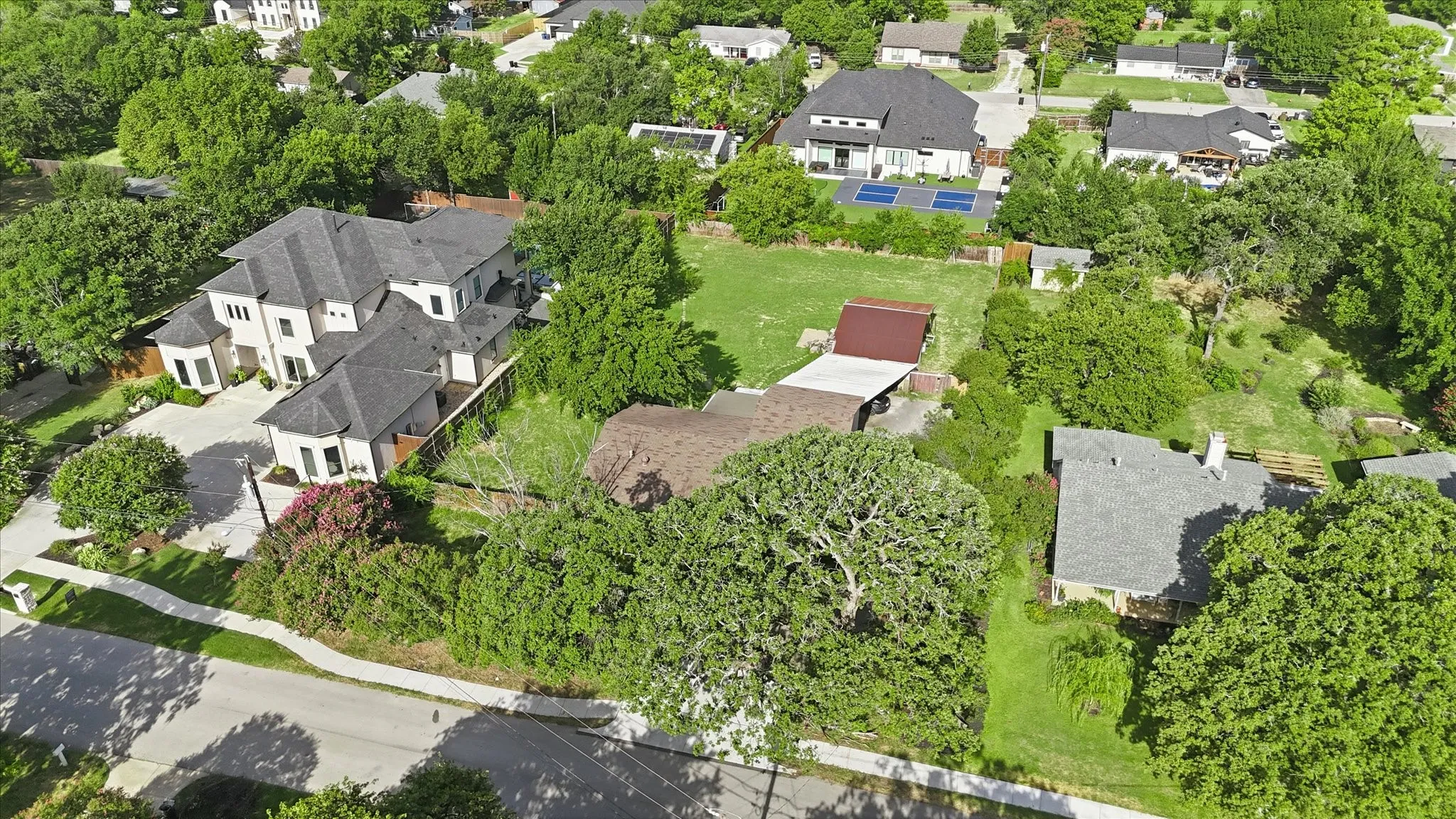 Aerial perspective showcasing expansive green spaces, mature trees, and a residential street