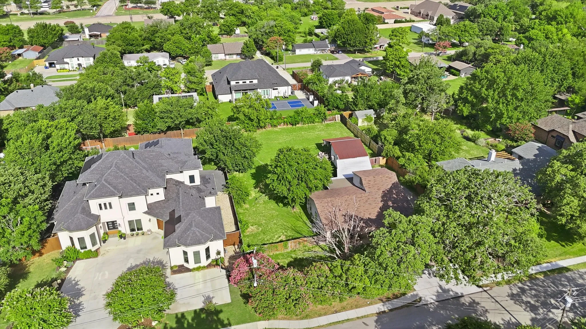 Expansive property featuring a large residence with a multi-gabled roof and a spacious paved driveway