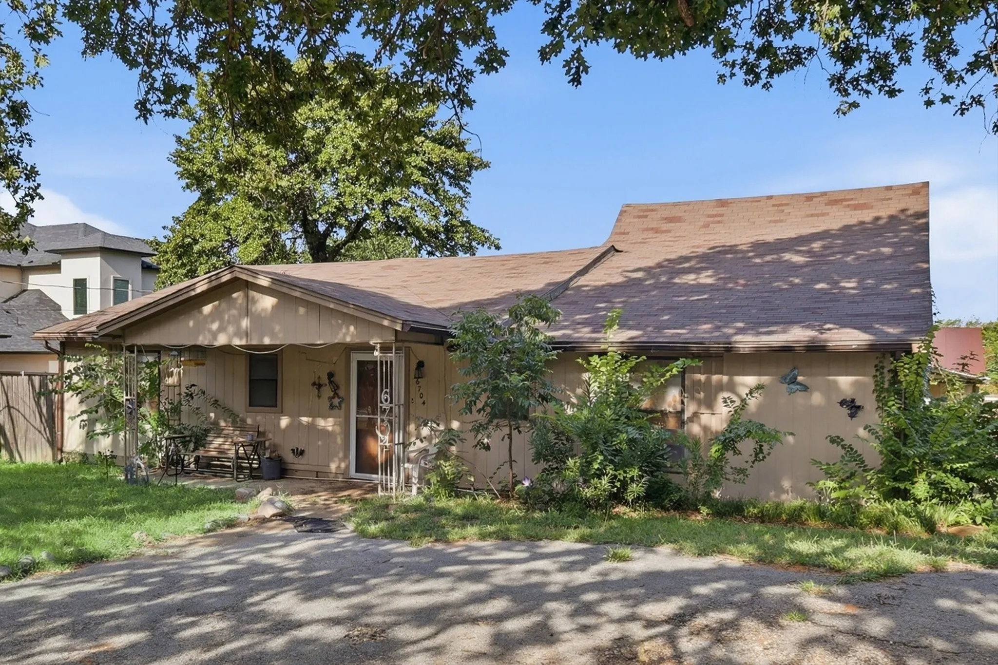 Single-story residence featuring a brown shingle roof and a covered front porch