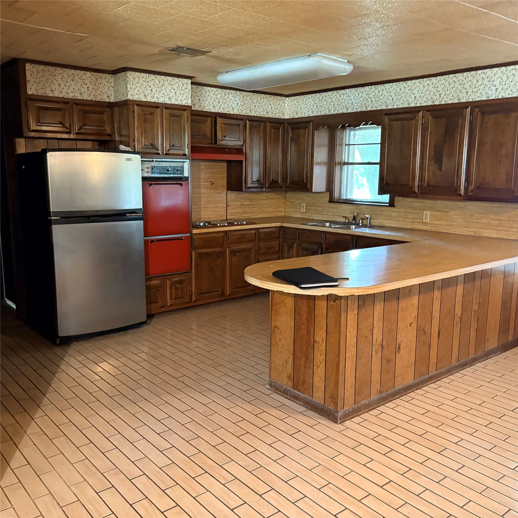 Spacious kitchen featuring extensive wood cabinetry and a wood-paneled breakfast bar