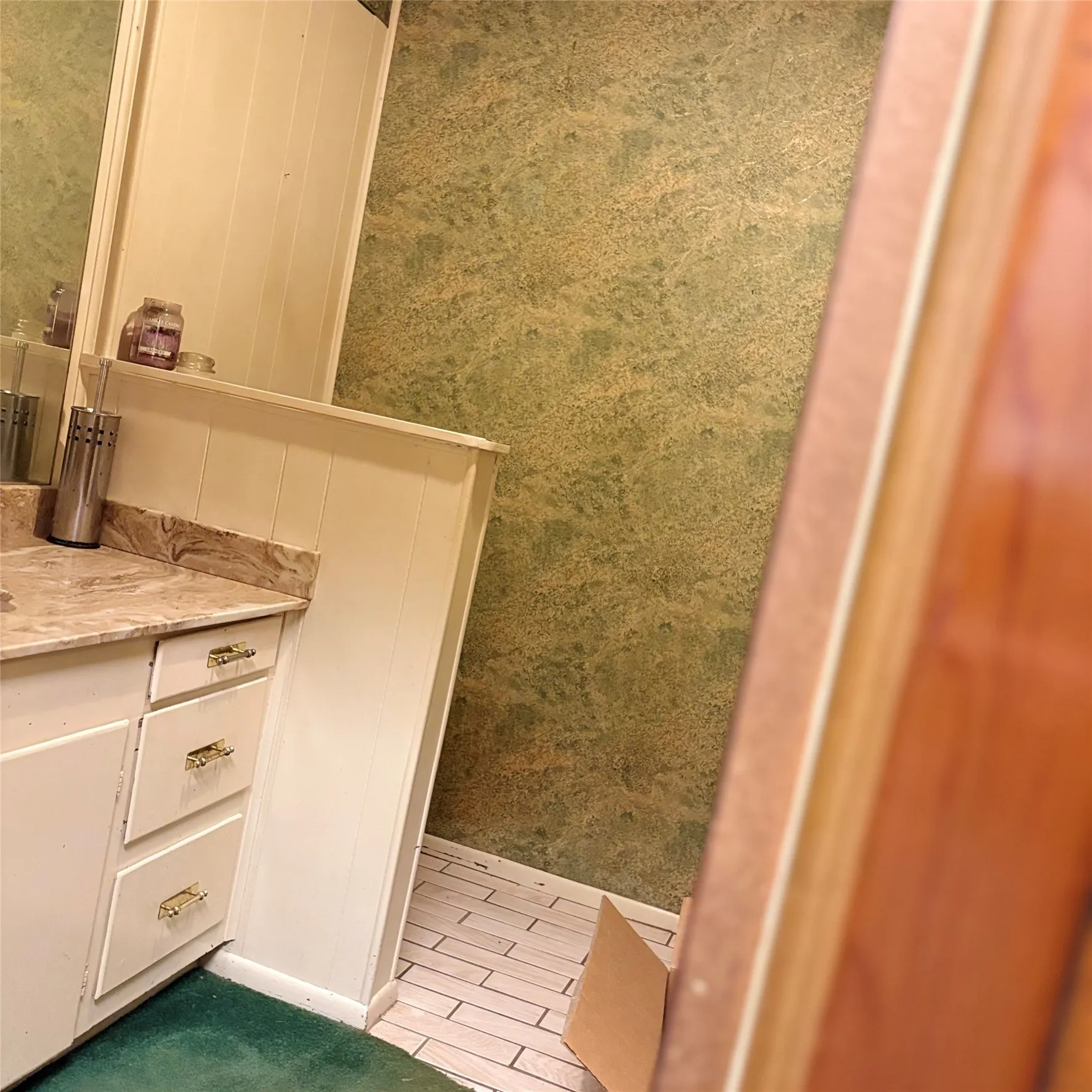 White vanity with brass hardware, marble-finish countertop, and integrated sink