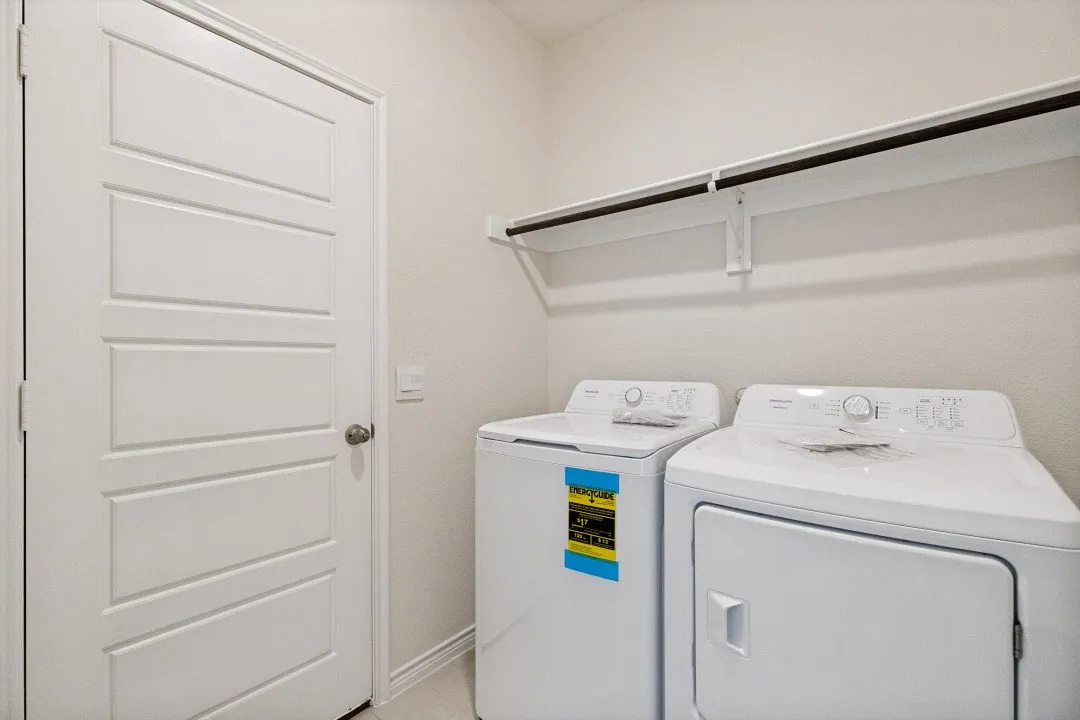 Dedicated laundry area featuring a shelf and hanging rod for organization