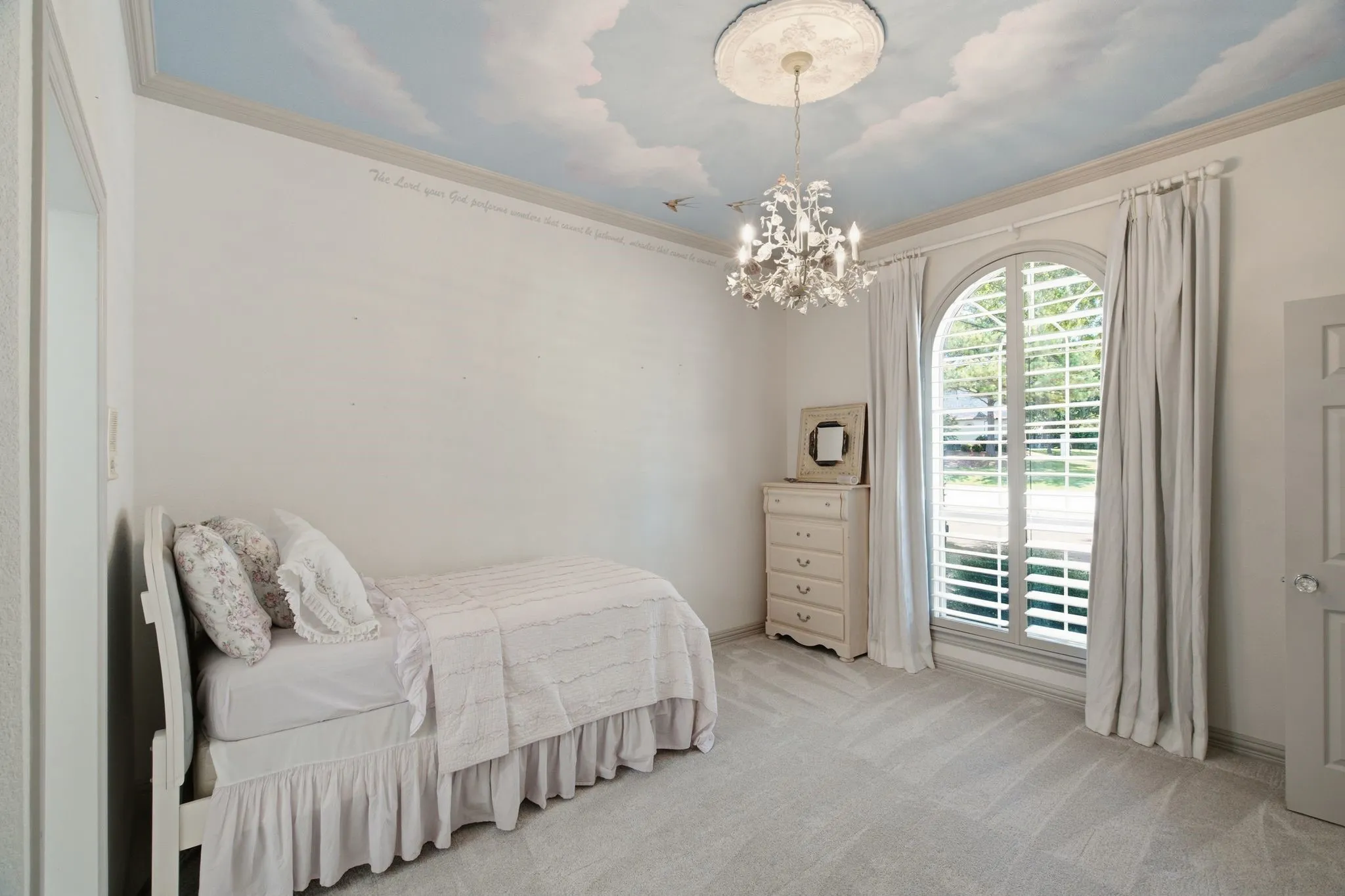 Arched window with plantation shutters and full-length drapes