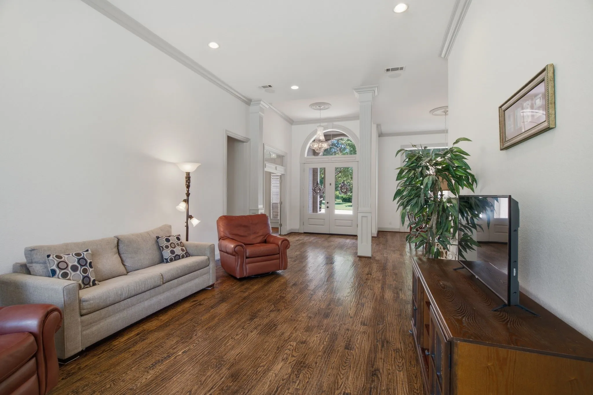 Entryway featuring wood-finish flooring, white walls, decorative crown molding, recessed lighting, and a double-door entryway with an arched transom