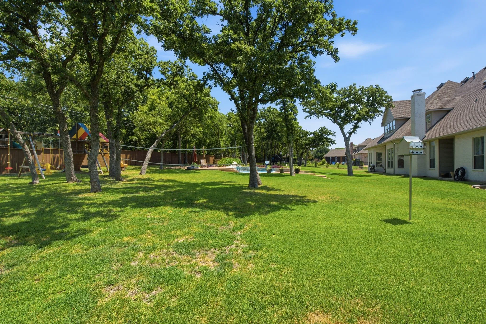Expansive green lawn featuring mature trees
