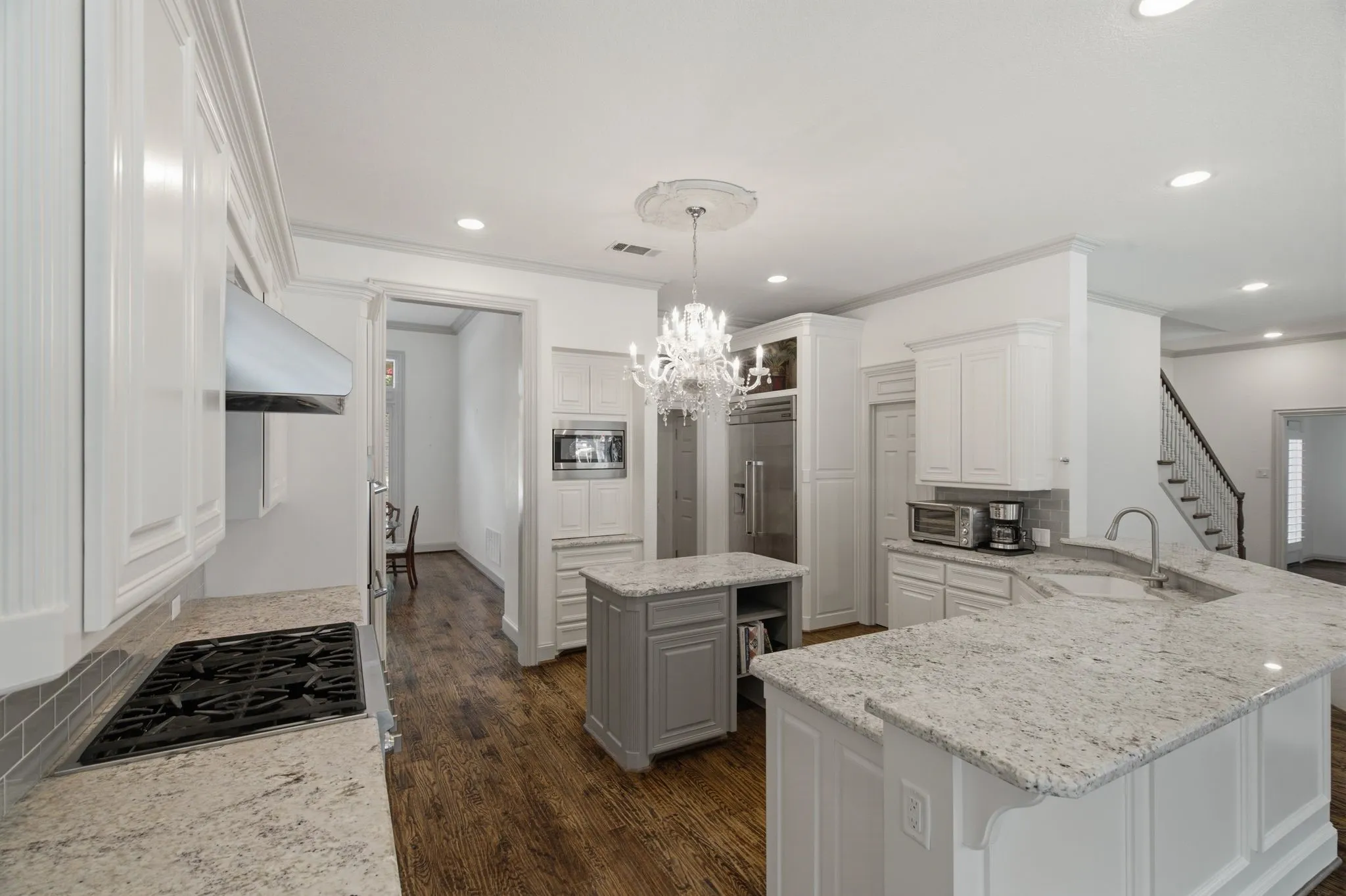Bright kitchen featuring white cabinetry and granite countertops
