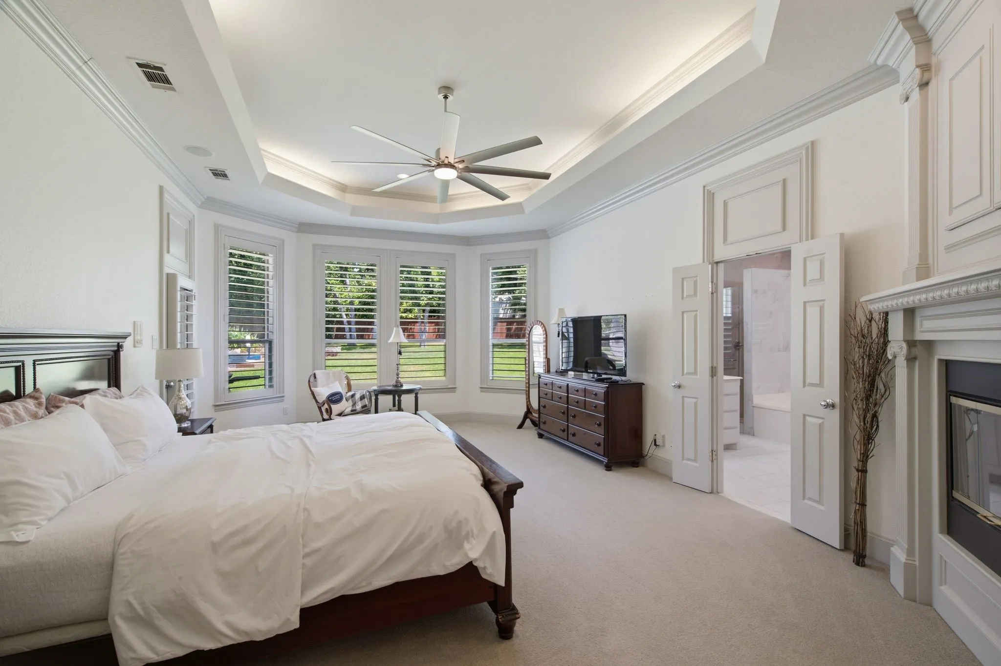 Room featuring a tray ceiling with recessed lighting and a ceiling fan