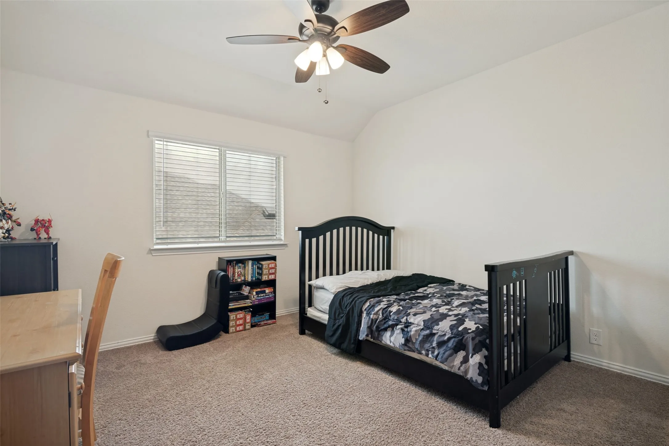 Carpeted room featuring a ceiling fan with integrated lighting, a window with horizontal blinds, and neutral wall tones