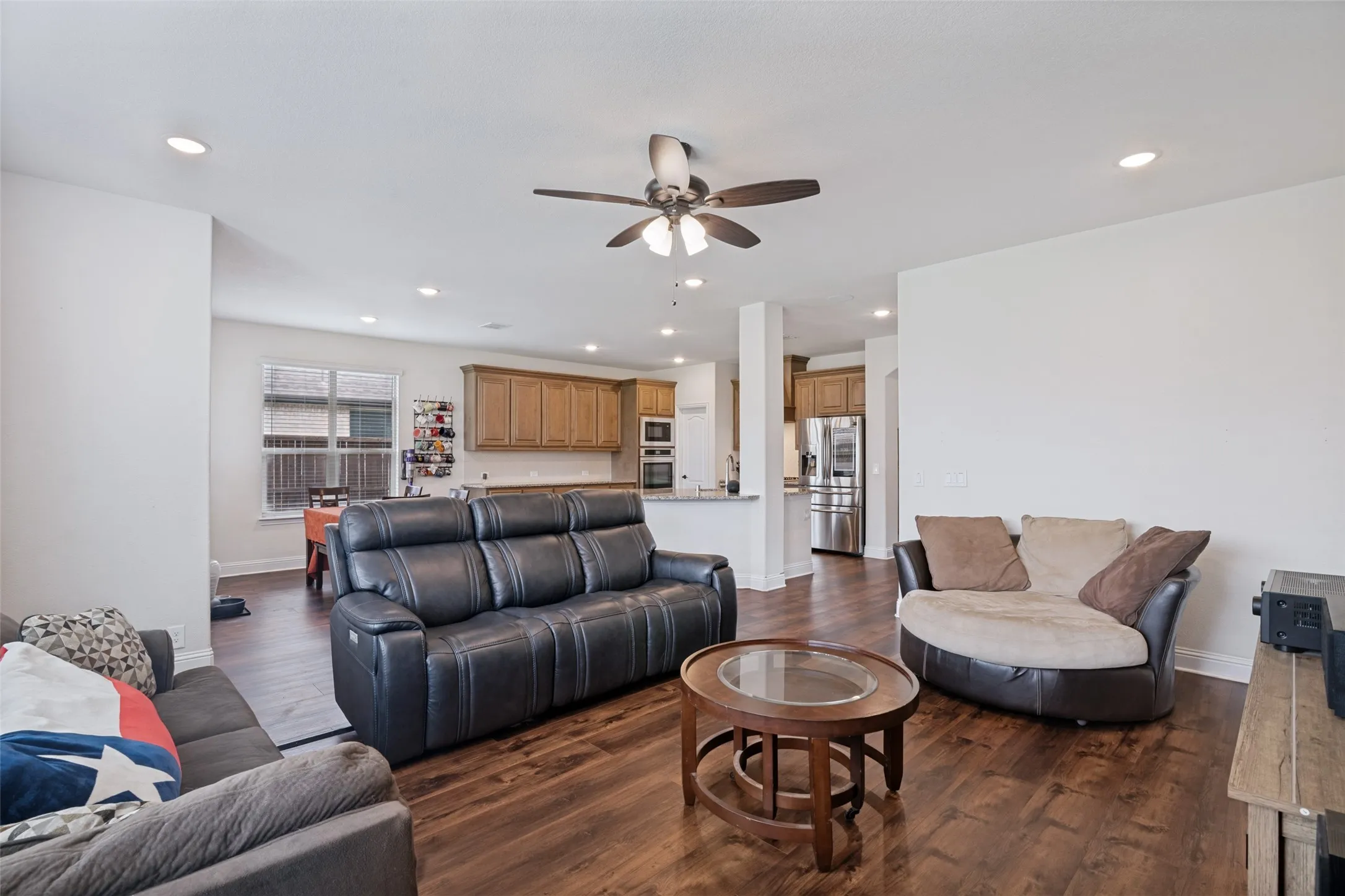 Open-concept living space featuring wood-finish flooring, recessed lighting, and a ceiling fan
