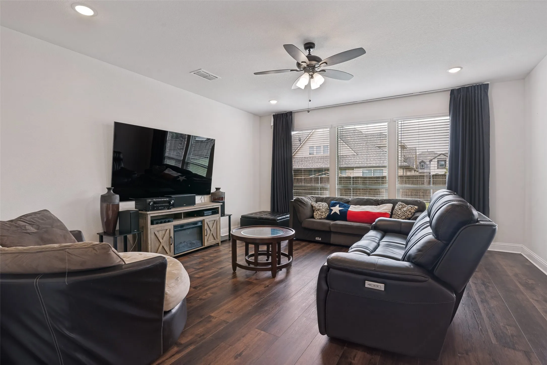 Spacious living area featuring wood-finish flooring, recessed lighting, and a ceiling fan