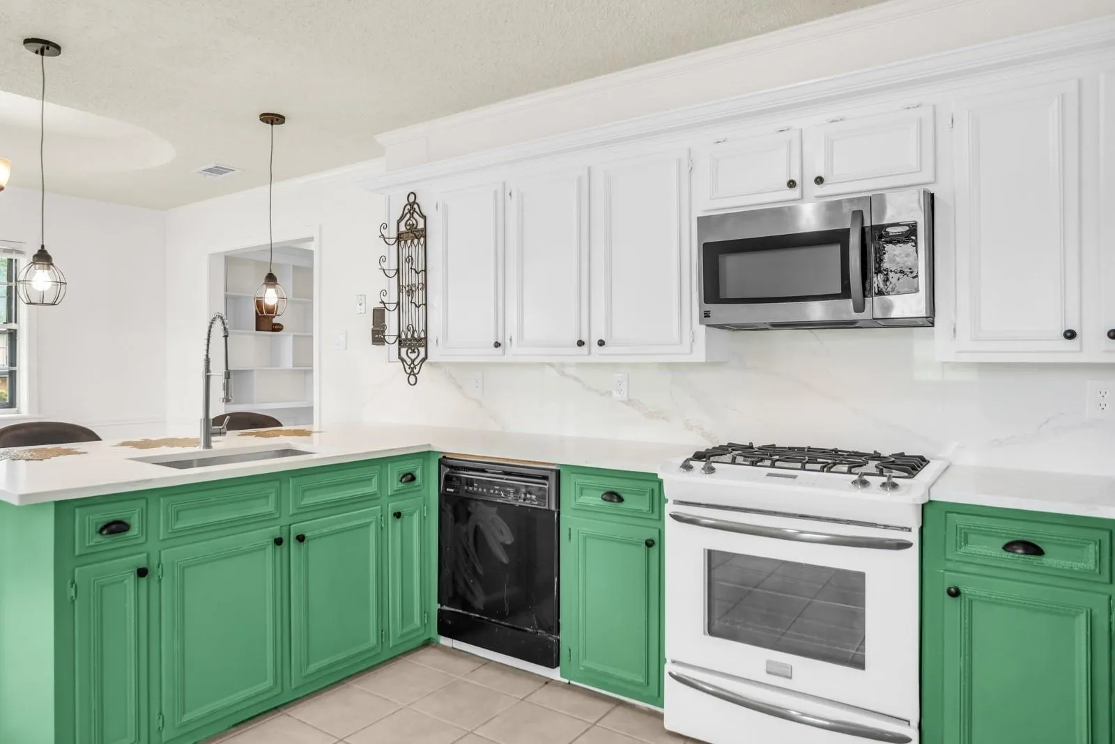 Kitchen featuring white upper cabinetry, green lower cabinetry, and light countertops