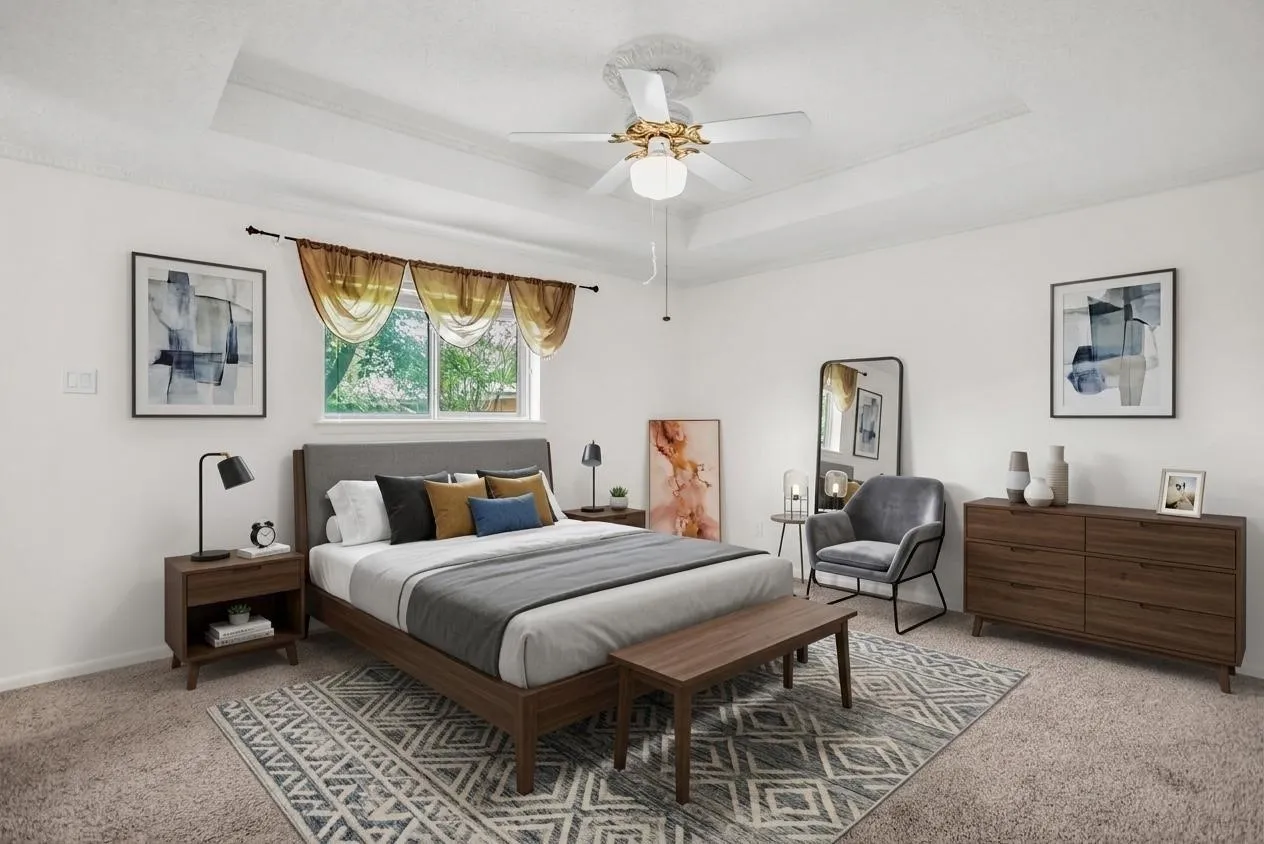 Spacious room featuring a tray ceiling, recessed window, and neutral carpeting