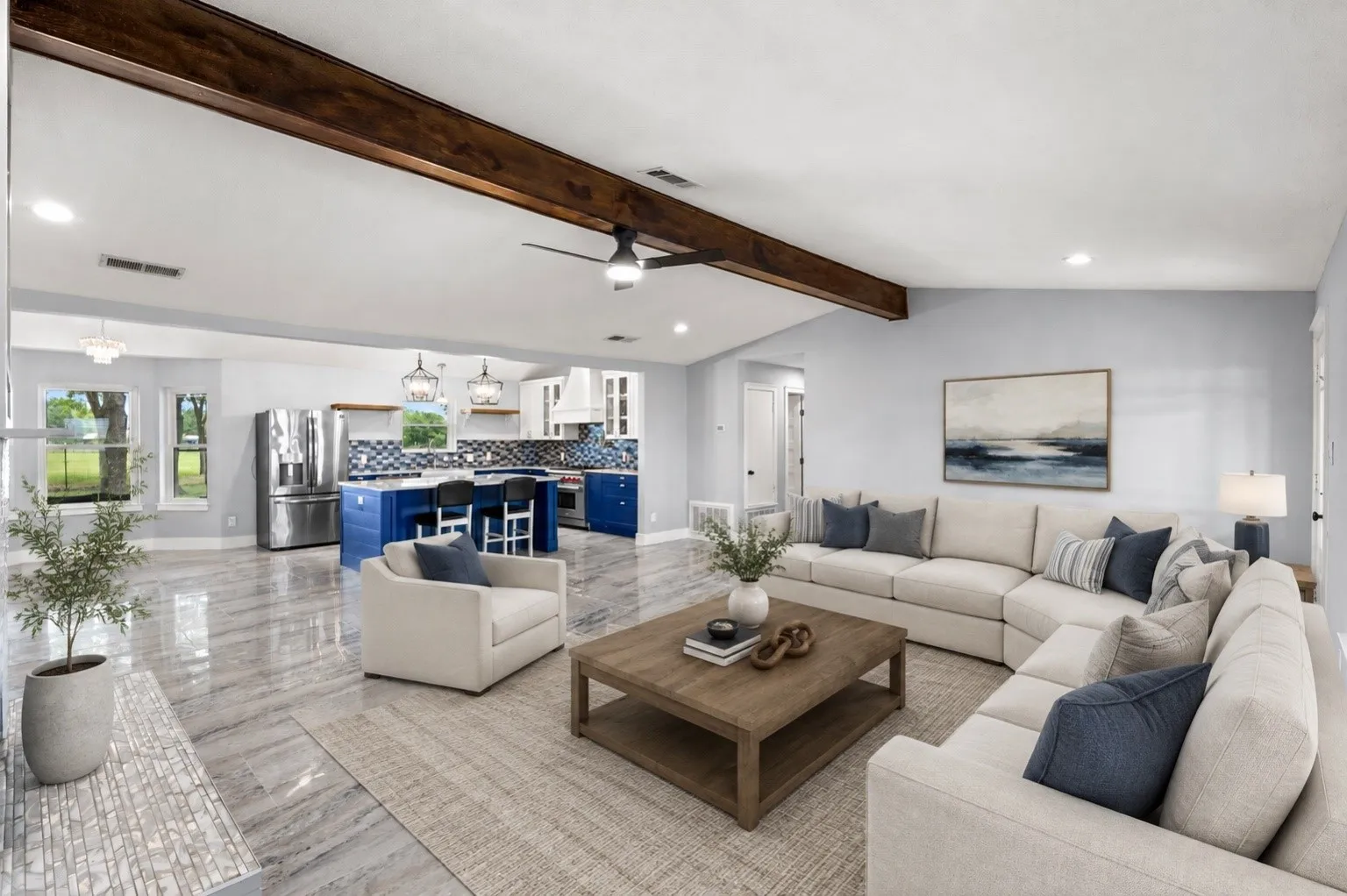 Open-concept living area with wood-finish ceiling beam, recessed lighting, and tile flooring