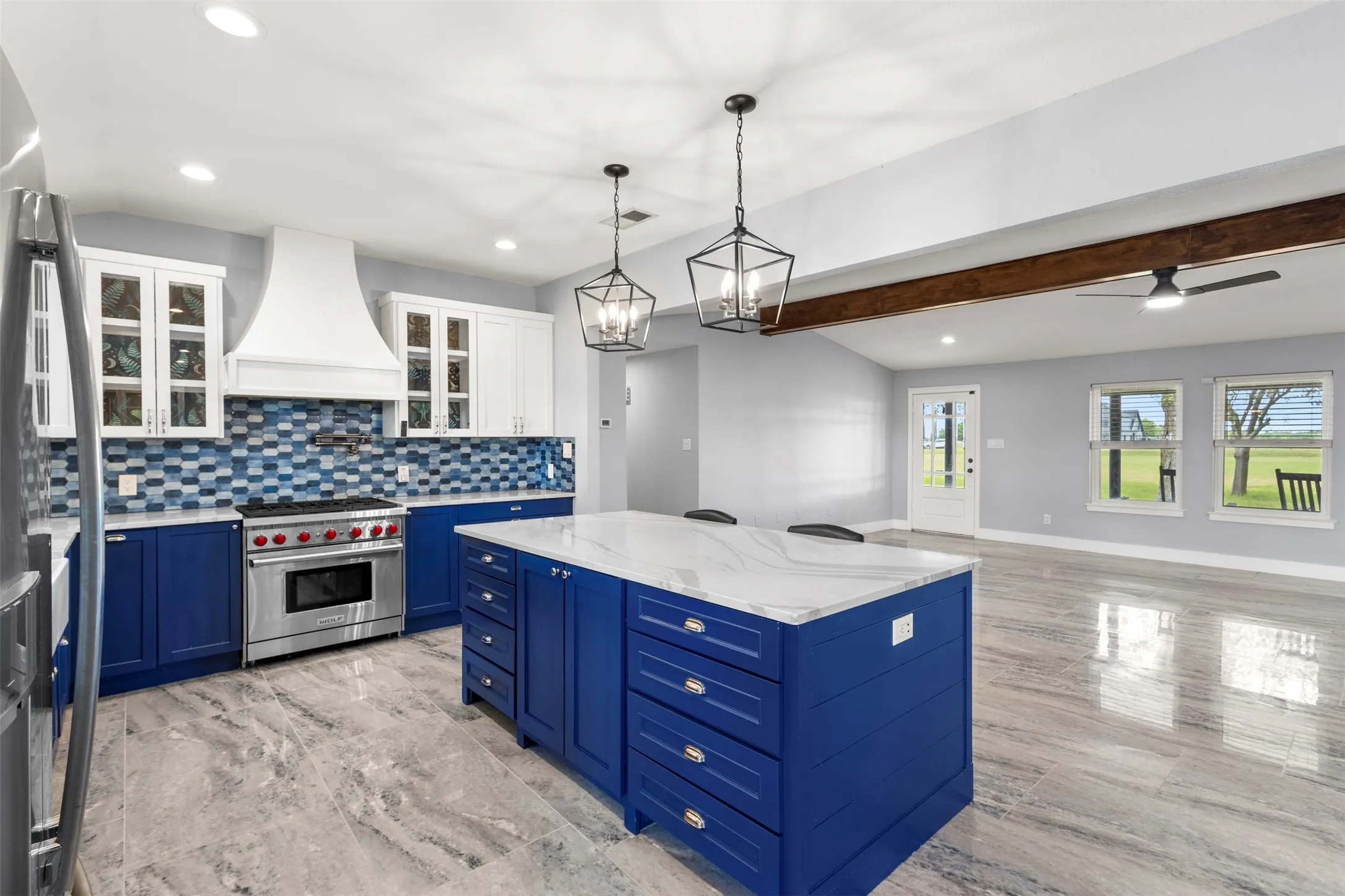 Spacious kitchen featuring a blue cabinet island with a white countertop
