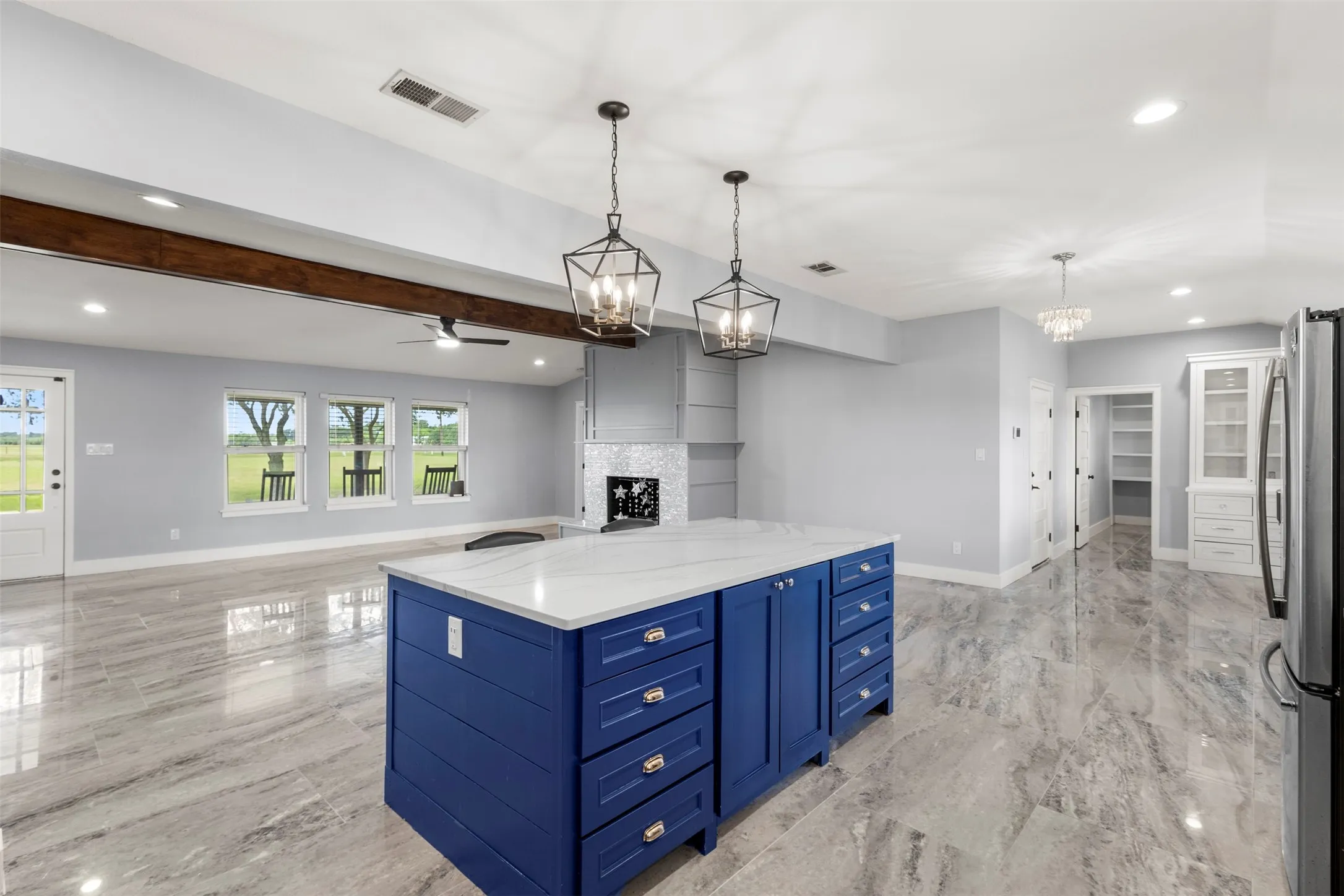 Central kitchen island with blue cabinetry and a white countertop