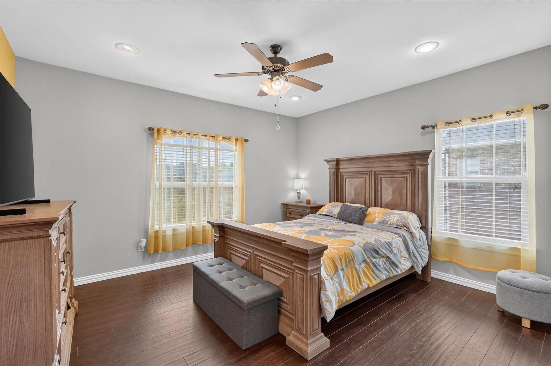 Spacious room featuring wood-finish flooring, recessed lighting, and a ceiling fan