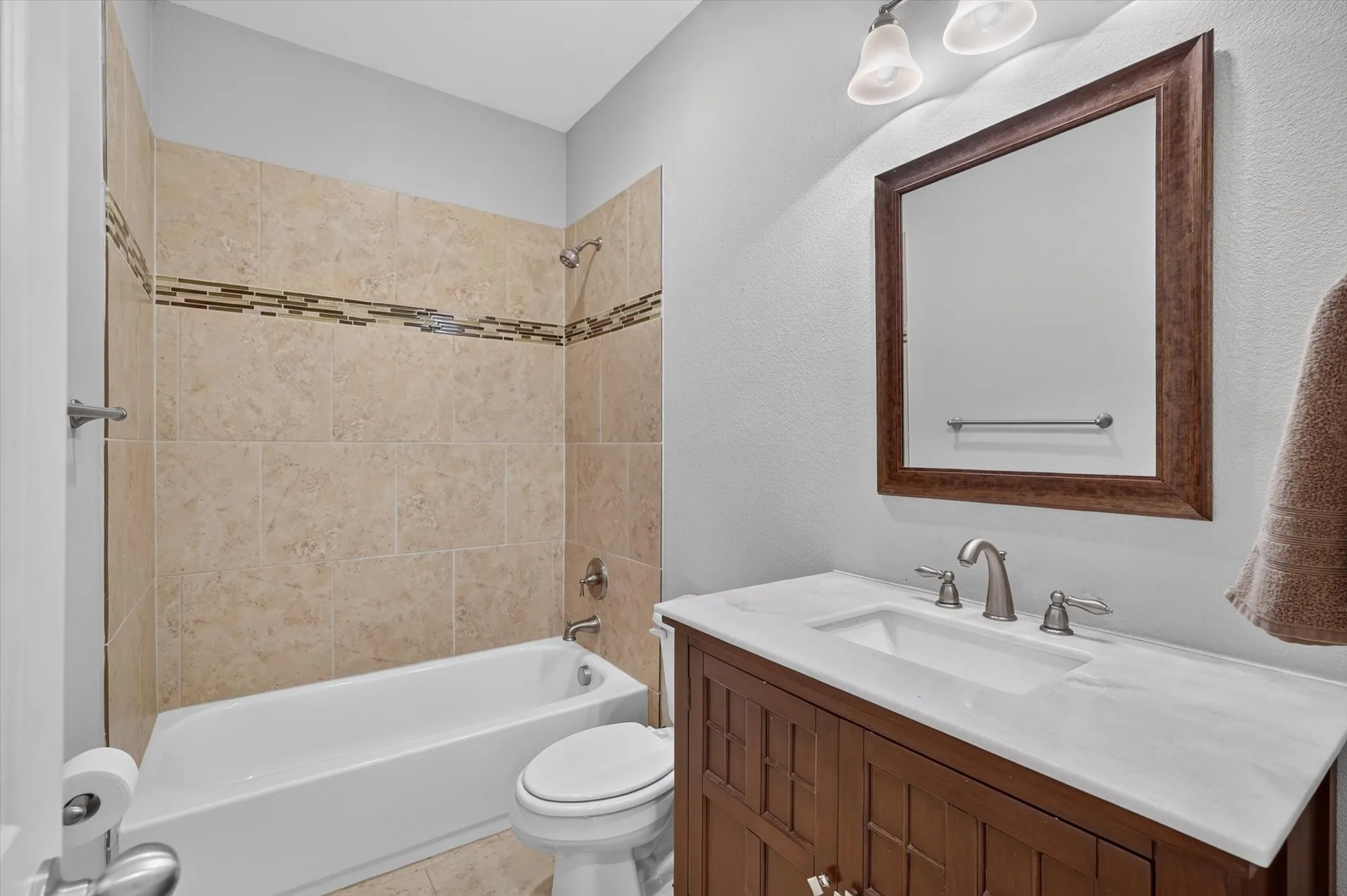 Bathroom featuring a full vanity with a white countertop and rectangular undermount sink, brushed nickel faucet, and a large framed mirror