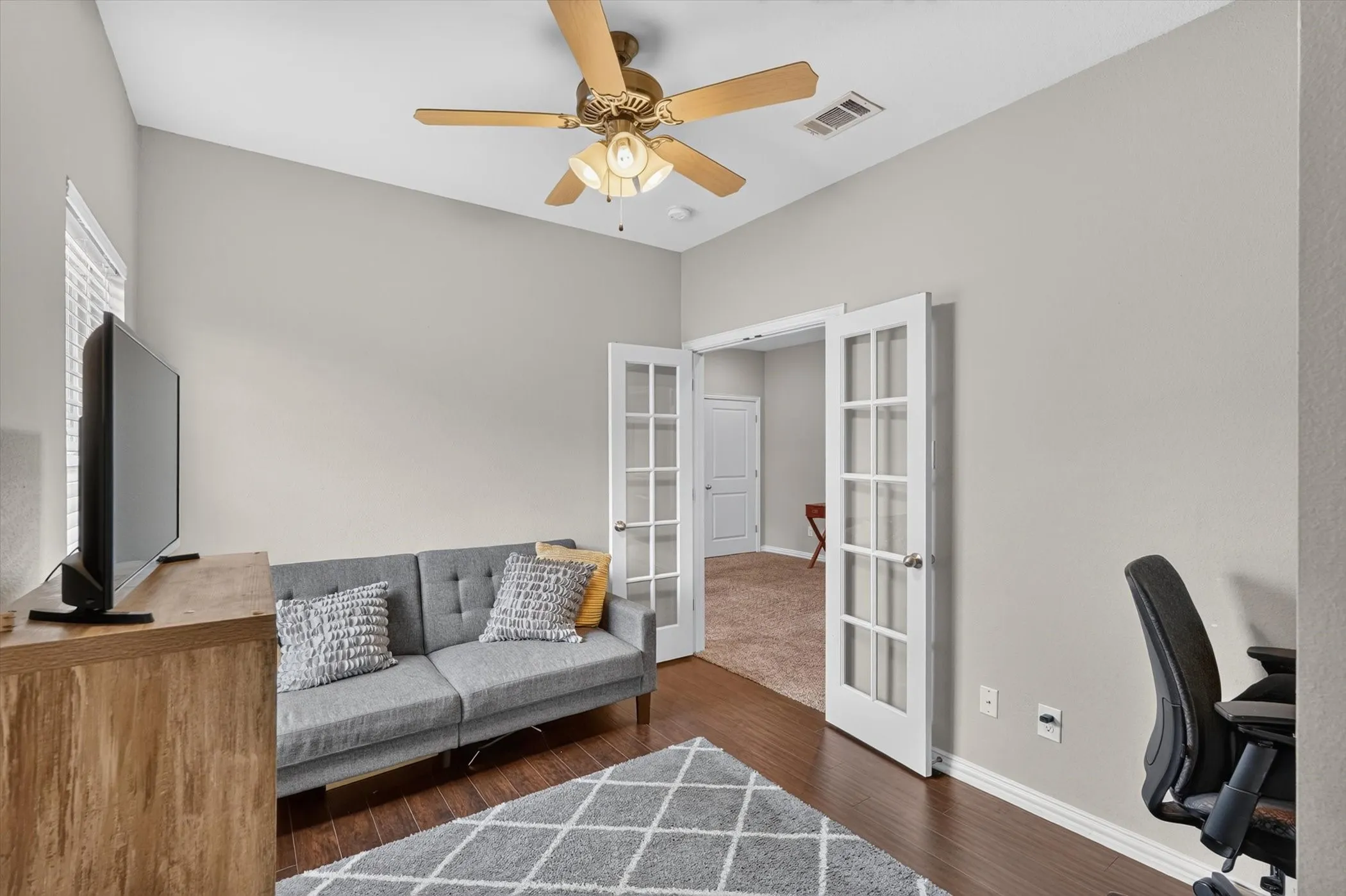 Room featuring high ceilings, dark wood-finish flooring, and white French doors