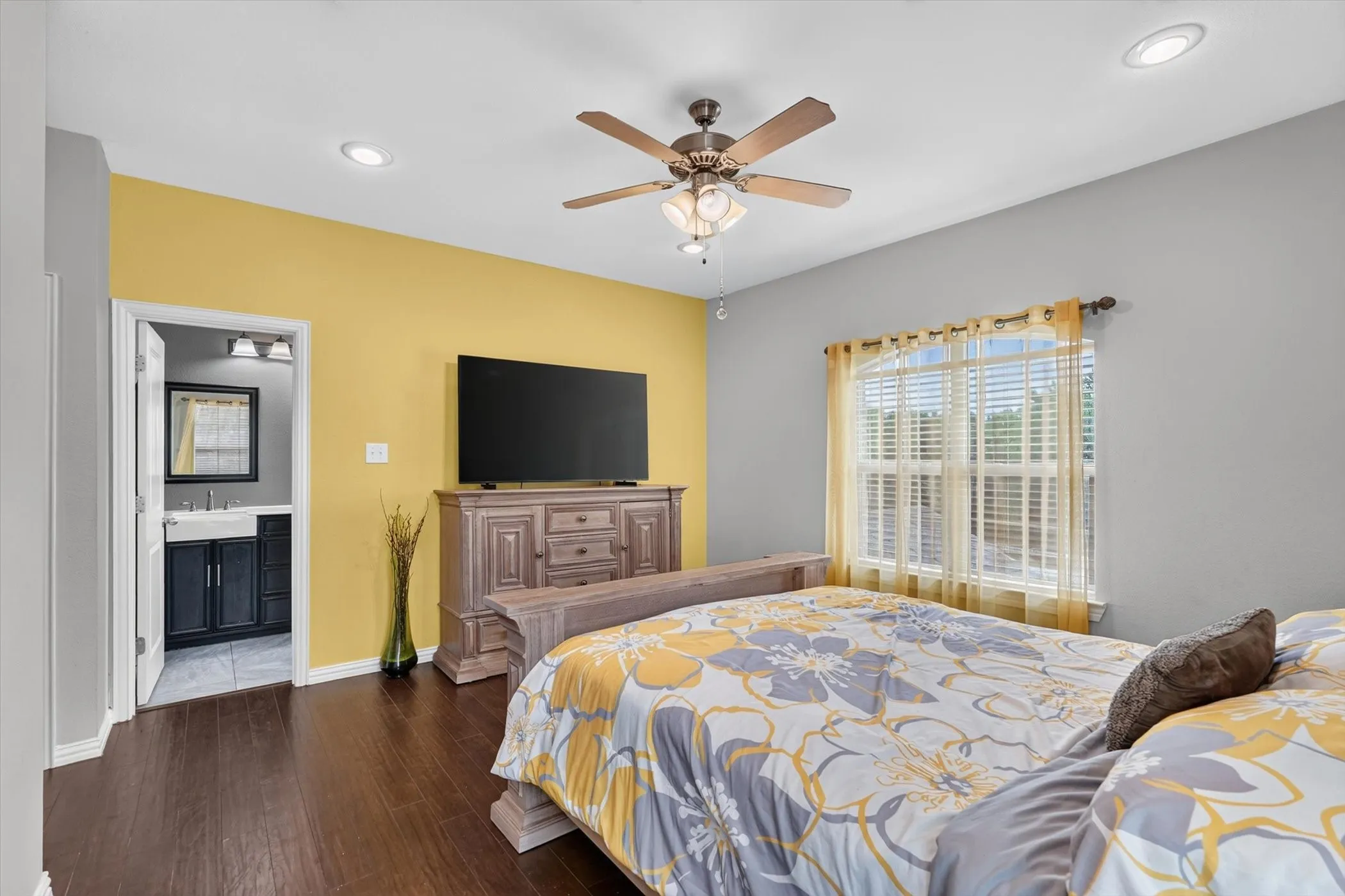 Spacious room featuring dark wood-finish flooring, recessed lighting, and a ceiling fan with integrated light