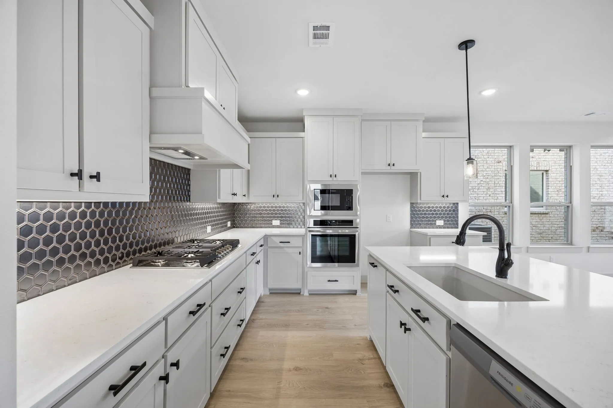 Beautiful cabinetry, gorgeous countertops and statement backsplash effortlessly pair with contemporary stainless steel to create a kitchen for the ages!