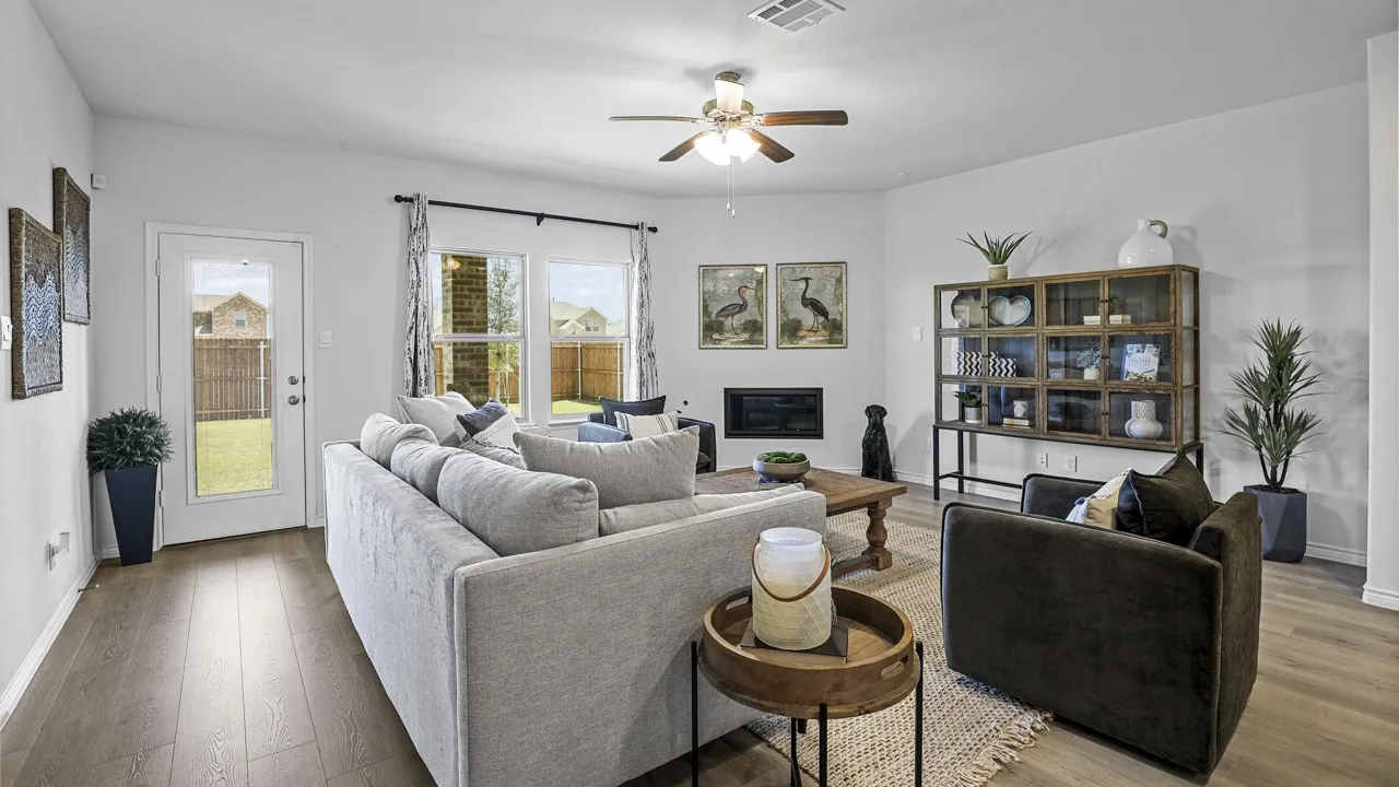 Living area featuring wood-finish flooring, a ceiling fan, and multiple windows