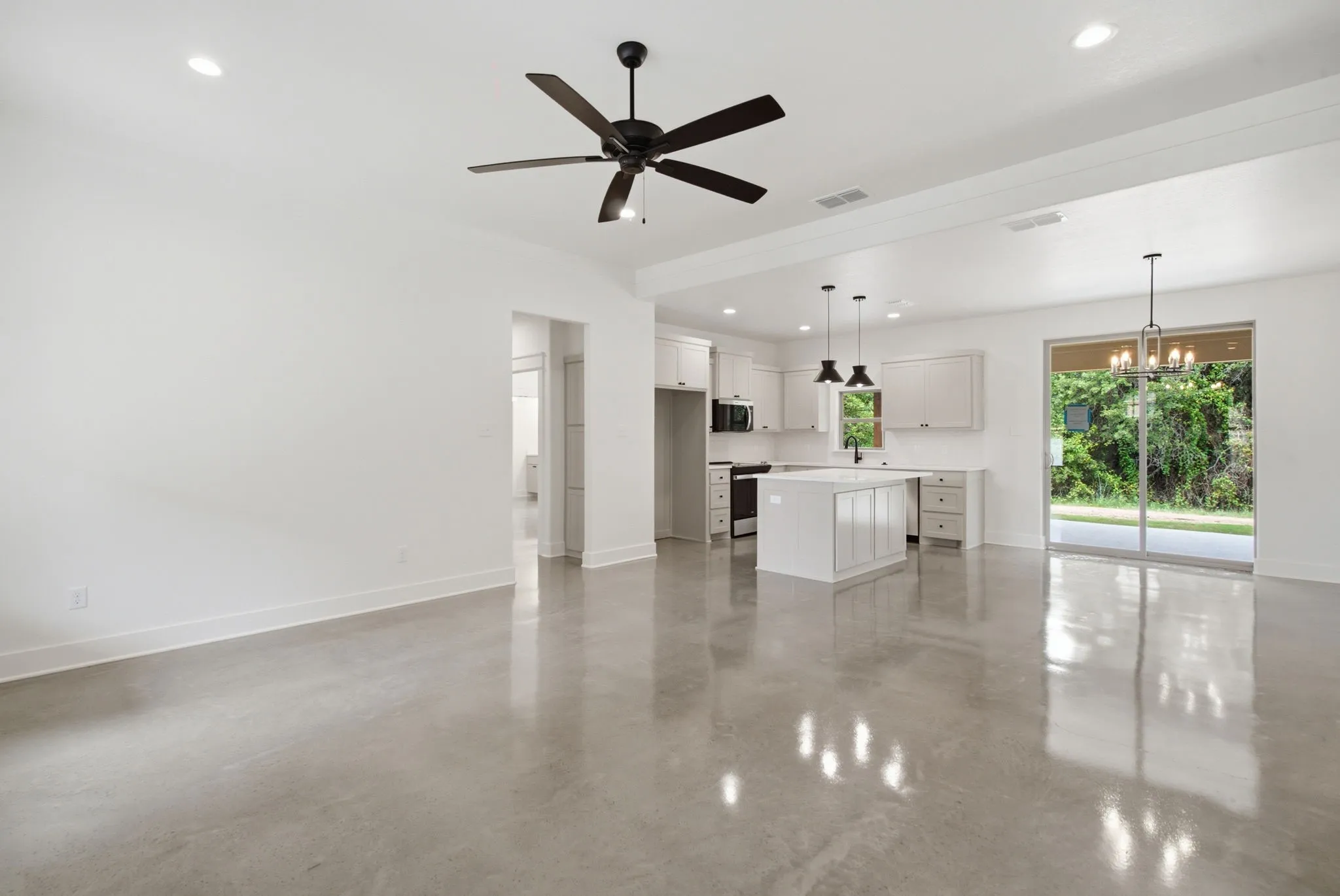 Open-concept living area featuring polished concrete flooring and recessed lighting
