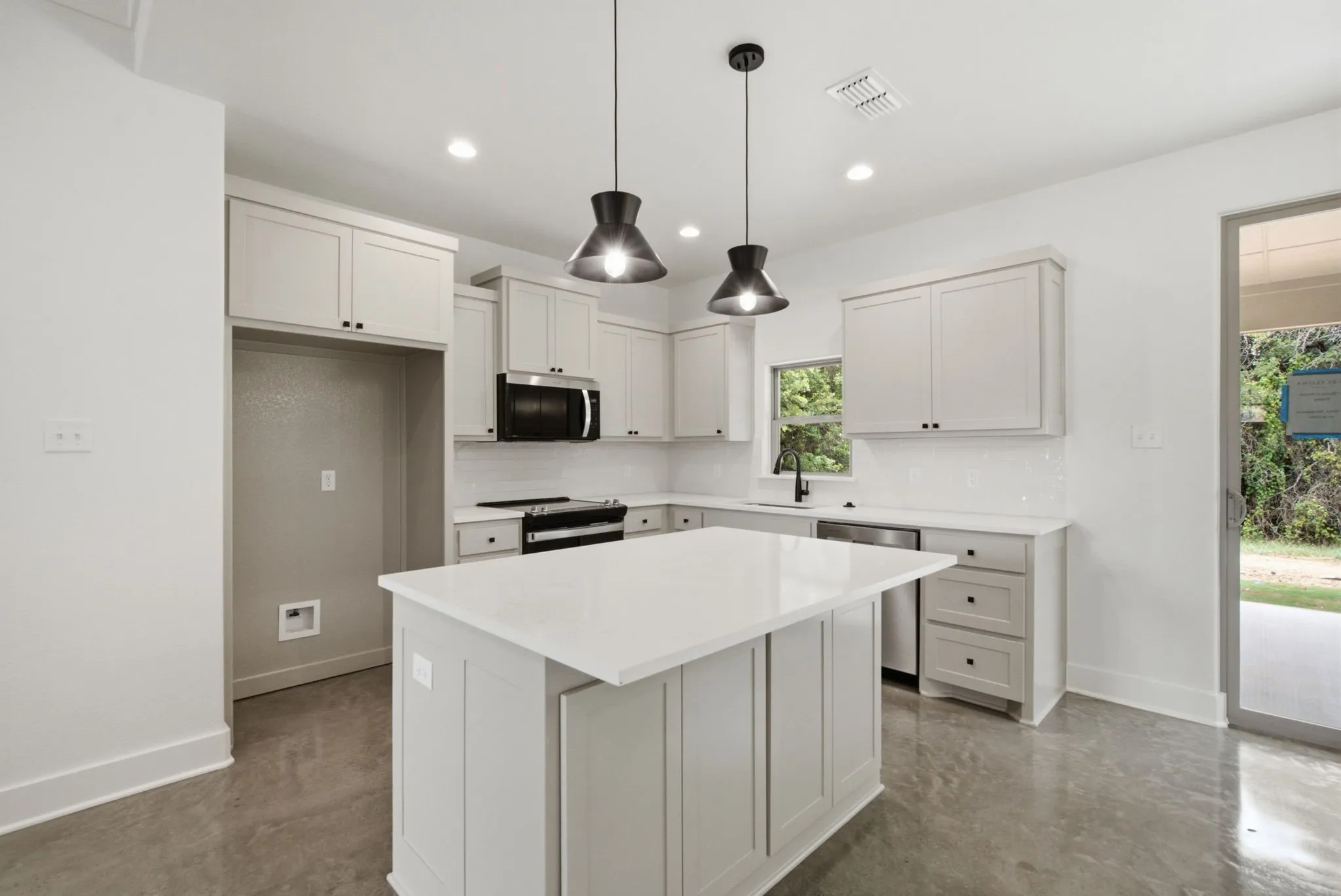 Kitchen featuring a central island with white countertop, light-toned cabinetry, white subway tile backsplash, and recessed lighting